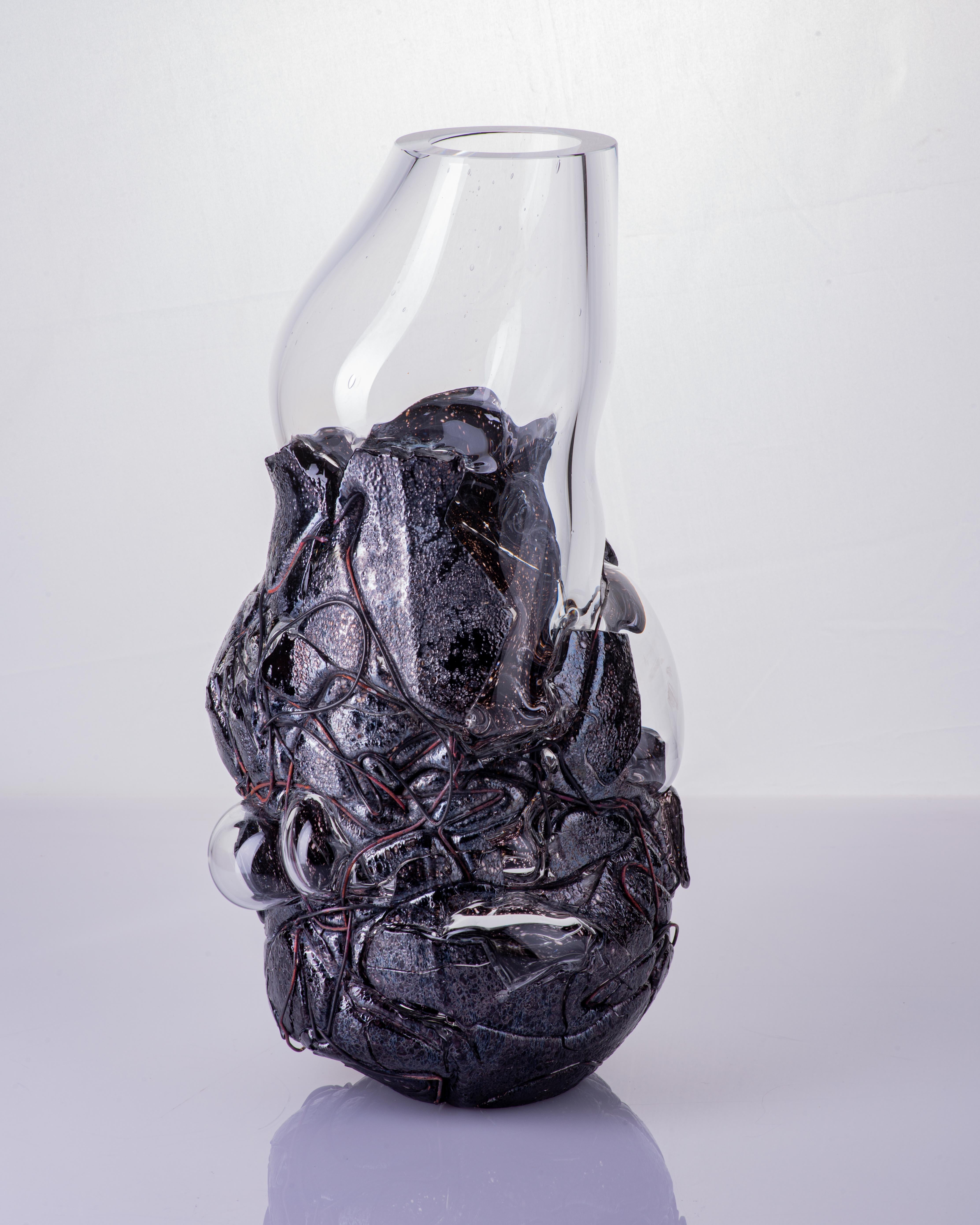 The Lava vases are an extension of the approach to colour and dimension that Anna Jožová has taken with the Keto series. They are a combination of two layers of glass and copper wire, where the flow of enamel through the modeled copper wire gives