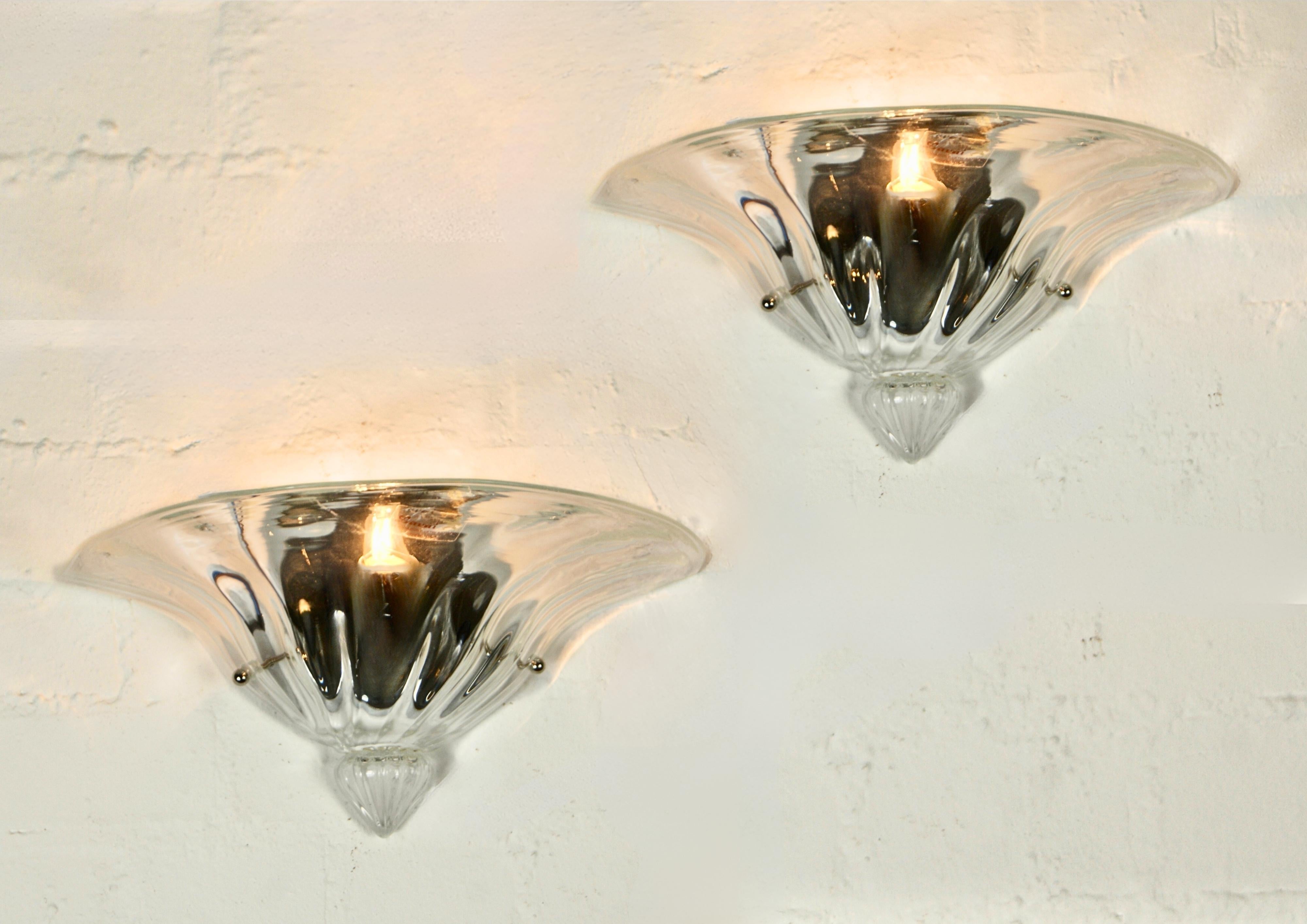 Pair of labeled clear glass crystal Murano glass wall sconces, circa 1990s.
Labeled 'LAVAI Lavarazione Vetri Artistici Venezia.
Beautiful mezza luna clam shaped clear crystal wall lamps.
Large sized at approximately 37cm wide.
 
The glass diffusers