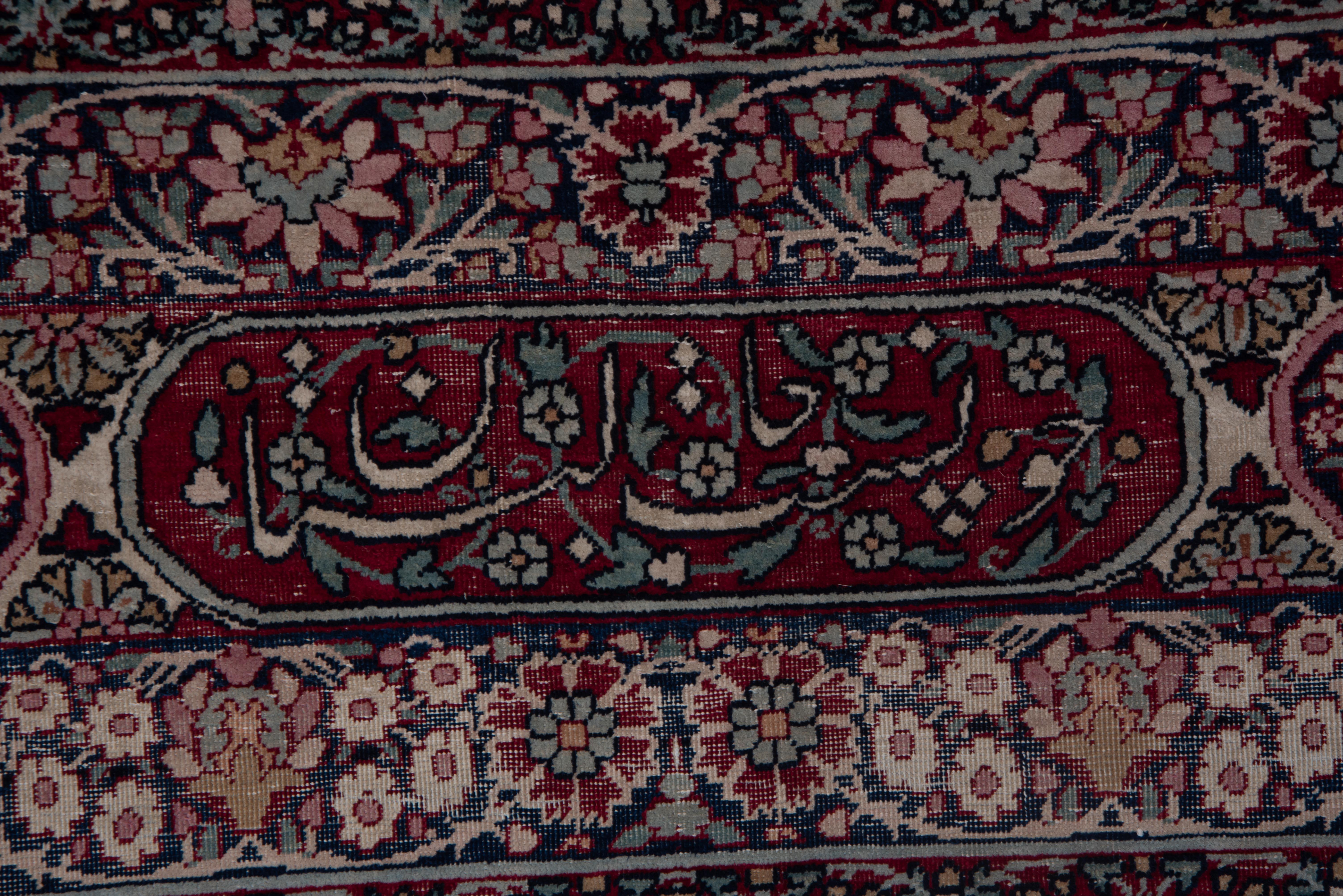 Champ floral à enroulement complexe dans les tons bordeaux et marine avec des touches de bleu ciel et d'ivoire. Encadrée par de rares bordures de style cartouche, cette pièce témoigne de l'élégance raffinée des traditions des ateliers de Kerman.