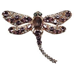 Broche libellule en métal doré avec strass lavande et transparent