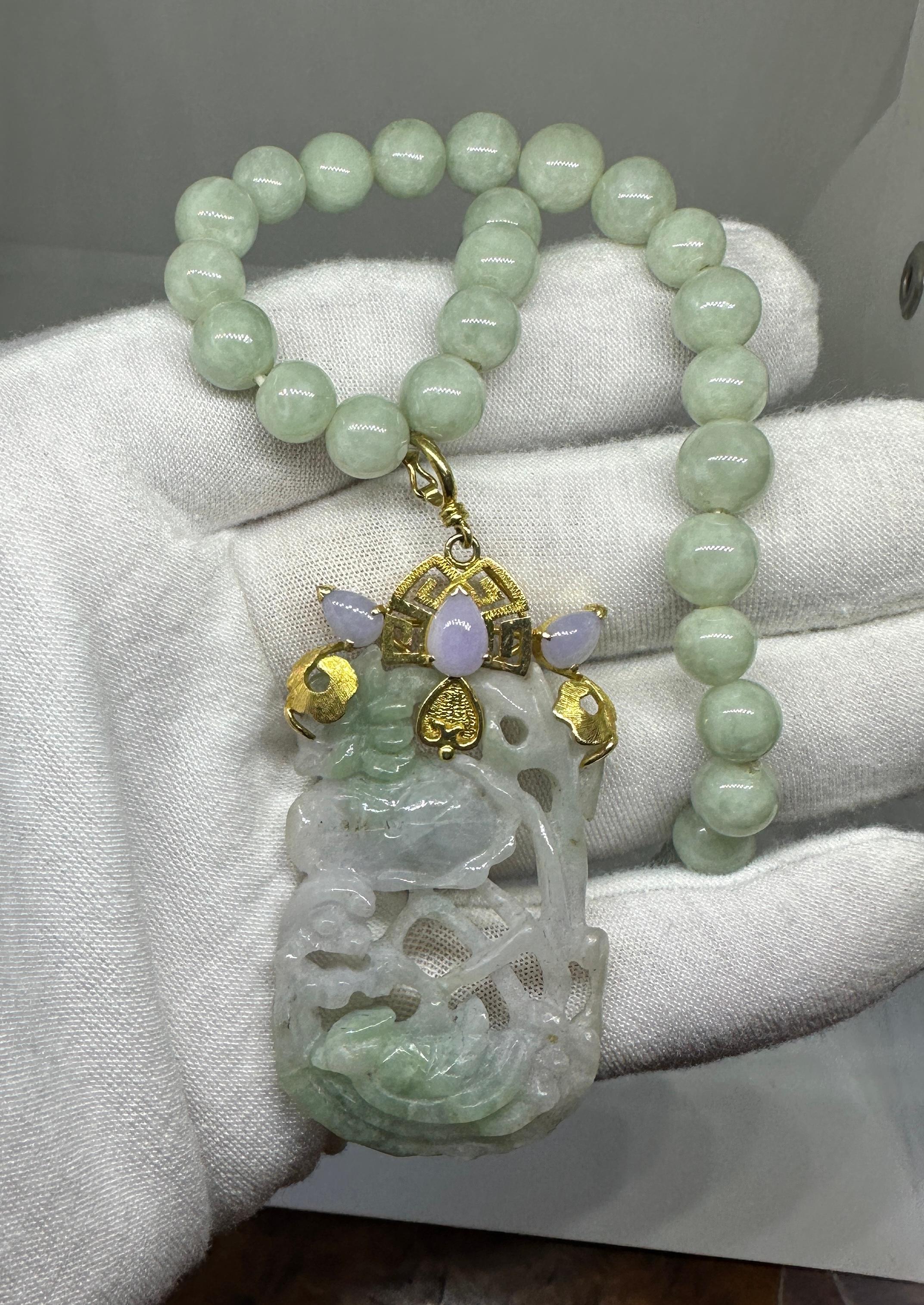 Si tratta di una spettacolare collana di giada antica in oro 20 carati con un magnifico ciondolo di 3 pollici con una giada verde e lavanda intagliata con un motivo di uccelli e fiori di loto a forma di ninfea di grande bellezza.   La giada è