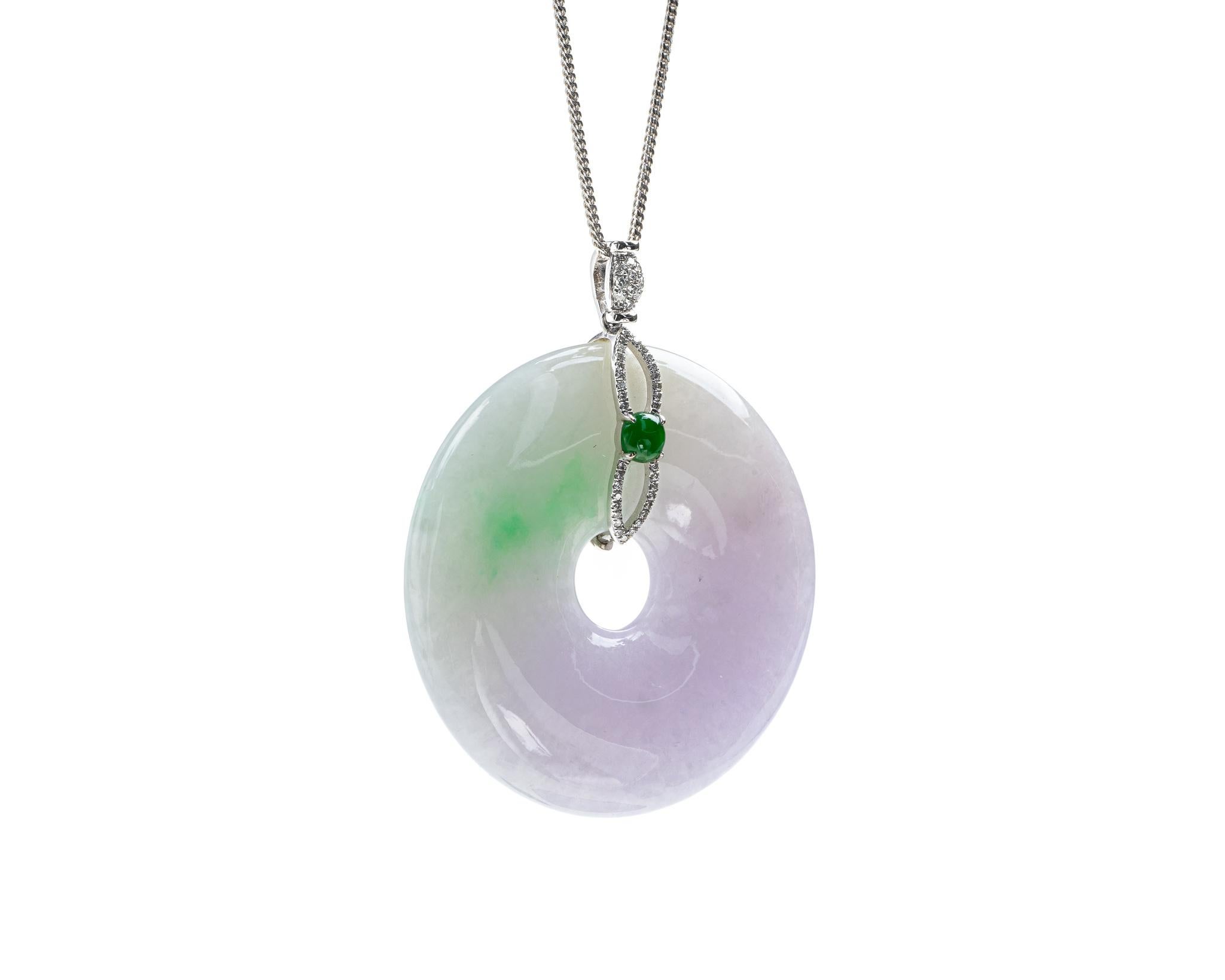 This is an all natural, untreated jadeite jade carved pi disc and diamond pendant set on an 18K white gold and diamond bail.  The carved pi disc symbolizes peace.  
 
It measures 2.05 inches (52.1 mm) x 1.70 inches (43.3 mm) with thickness of 0.30