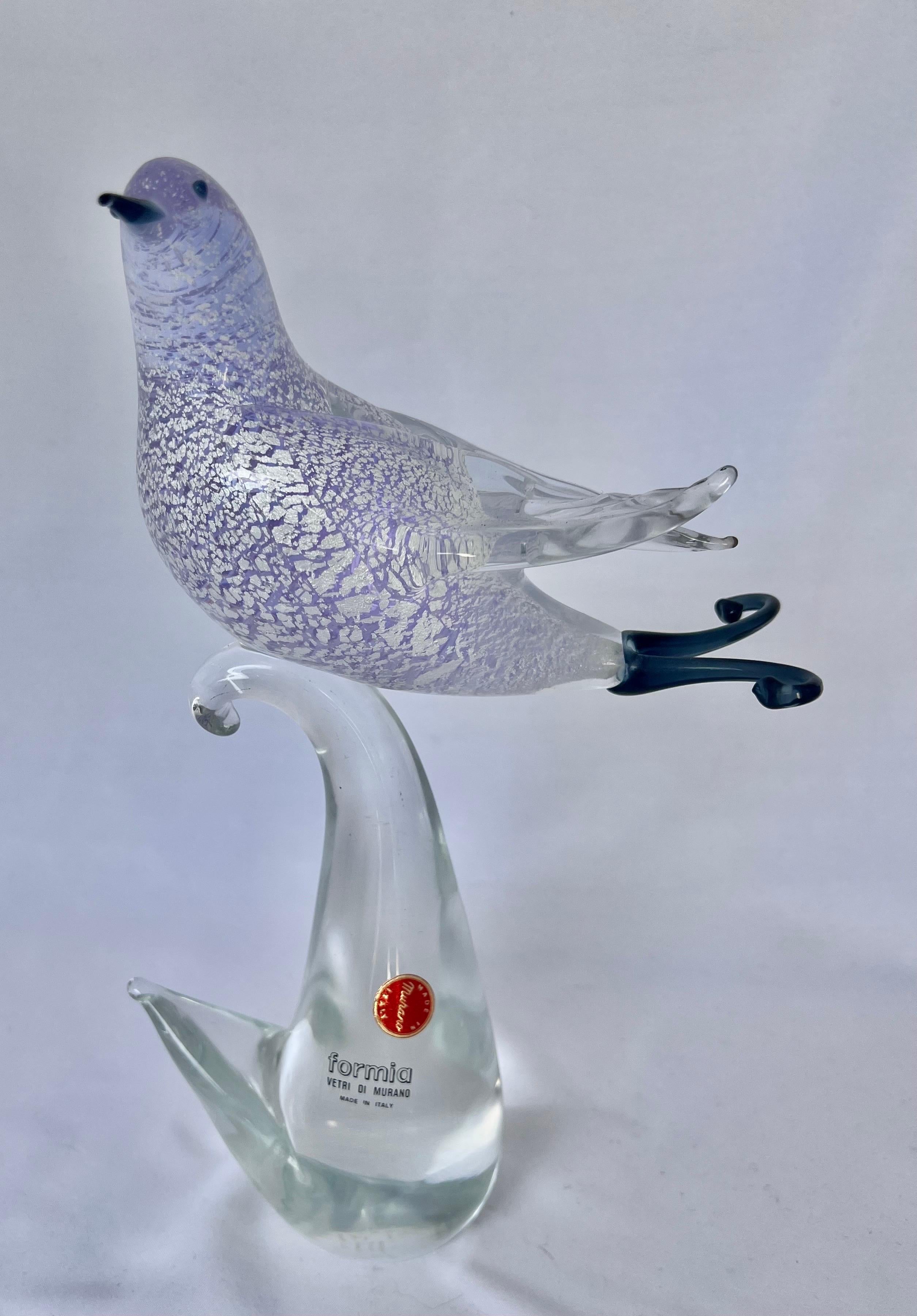 Vintage hand blown Formia Vetri Di MURANO glass bird in a lavender and silver coloration perched on a clear colored base. The glass bird still has it's Murano label.