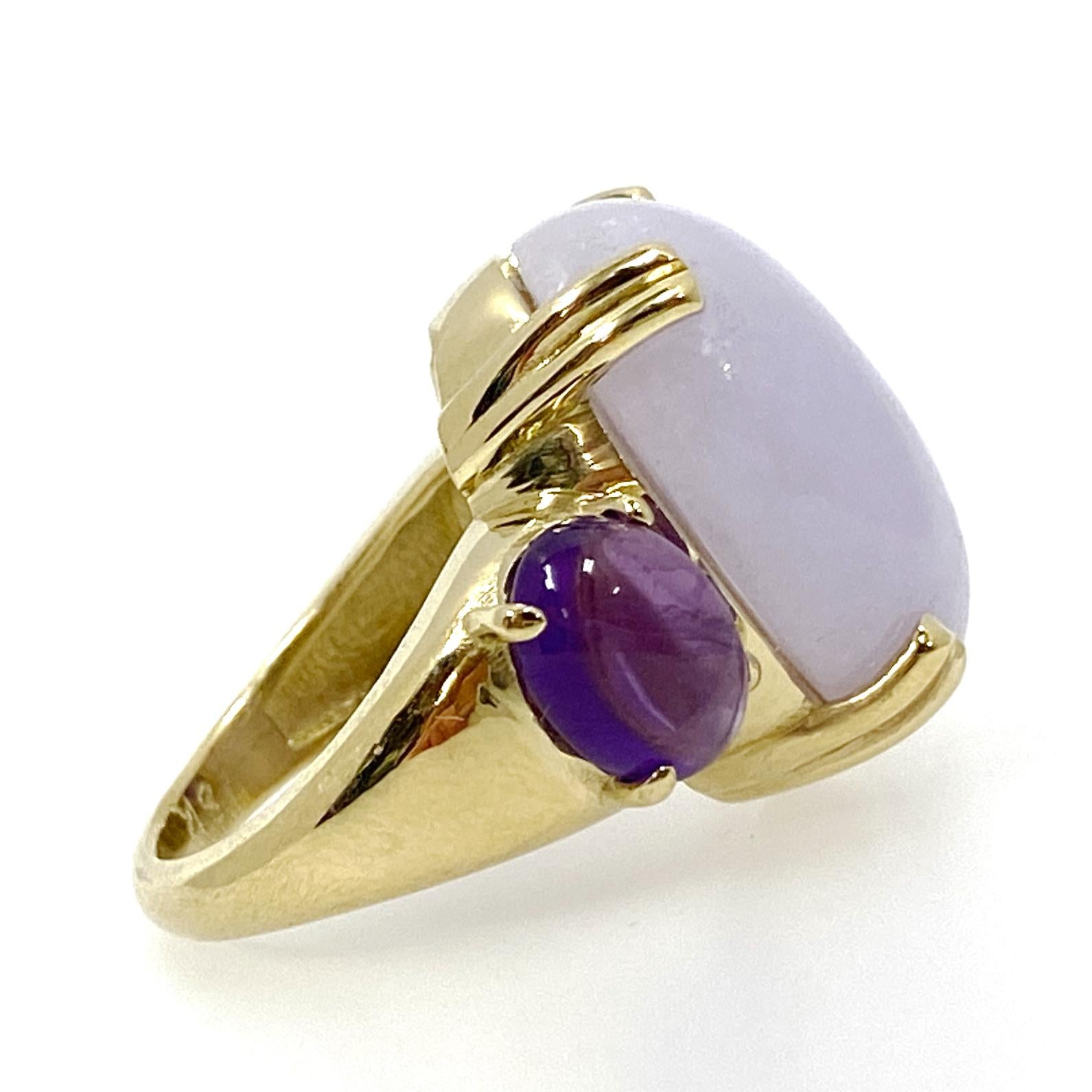 Eytan Brandes ensures a huge pale lavender jadeite cabochon is sitting pretty, centered between two dark purple amethysts in a bold and substantial high-polish 18 karat gold cocktail ring.

The natural, undyed jade cabochon is set with prominent