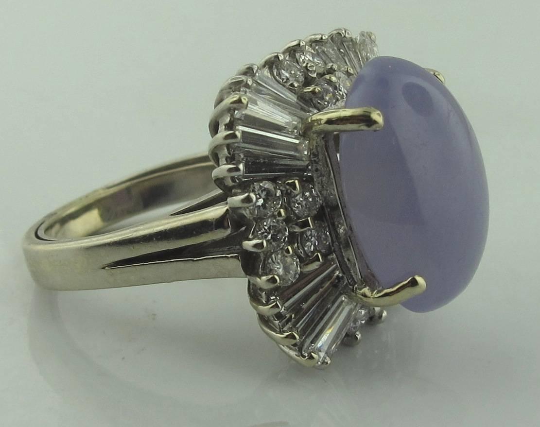 Set in Platinum, the center cabochon cut Lavender Jade stone weighs 11 carats.  It is surrounded by 20 tapered baguette diamonds with a total weight of 2.00 carats plus 18 round brilliant diamonds with a total weight of 0.65 carats.  Ring is size 6.5