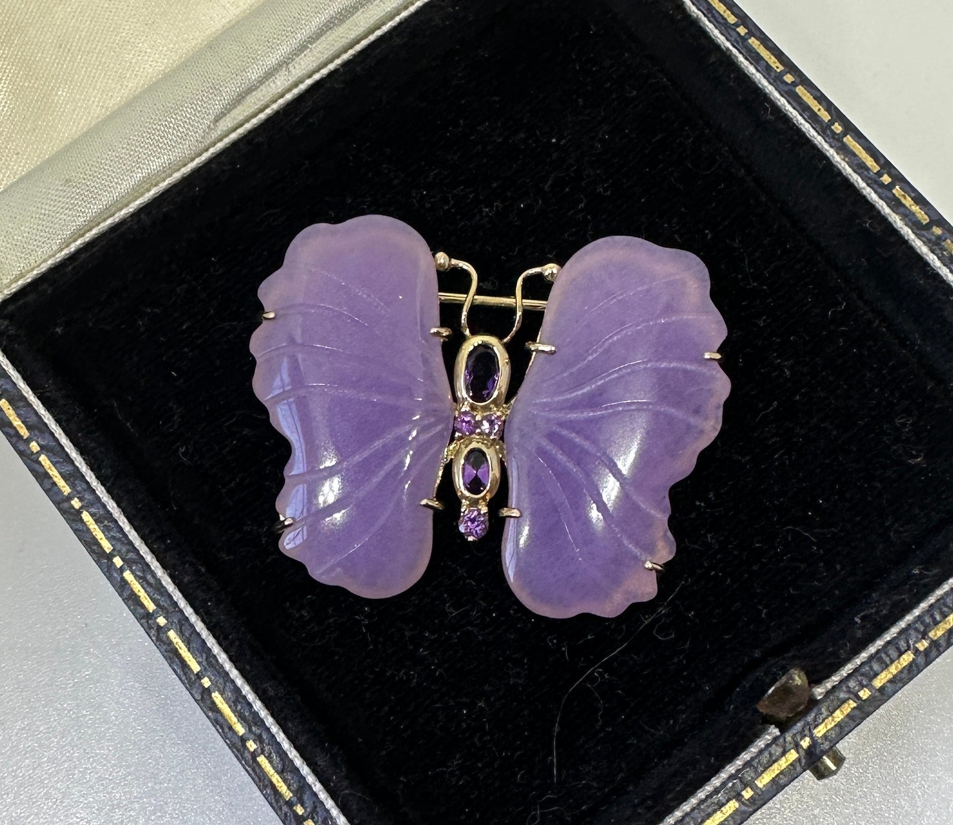 Si tratta di una splendida spilla a forma di farfalla insetto falena in giada lavanda e ametista, realizzata in oro giallo 10 carati.  Le ali della farfalla sono di bellissima giada lavanda intagliata.  Il colore della giada lavanda è assolutamente