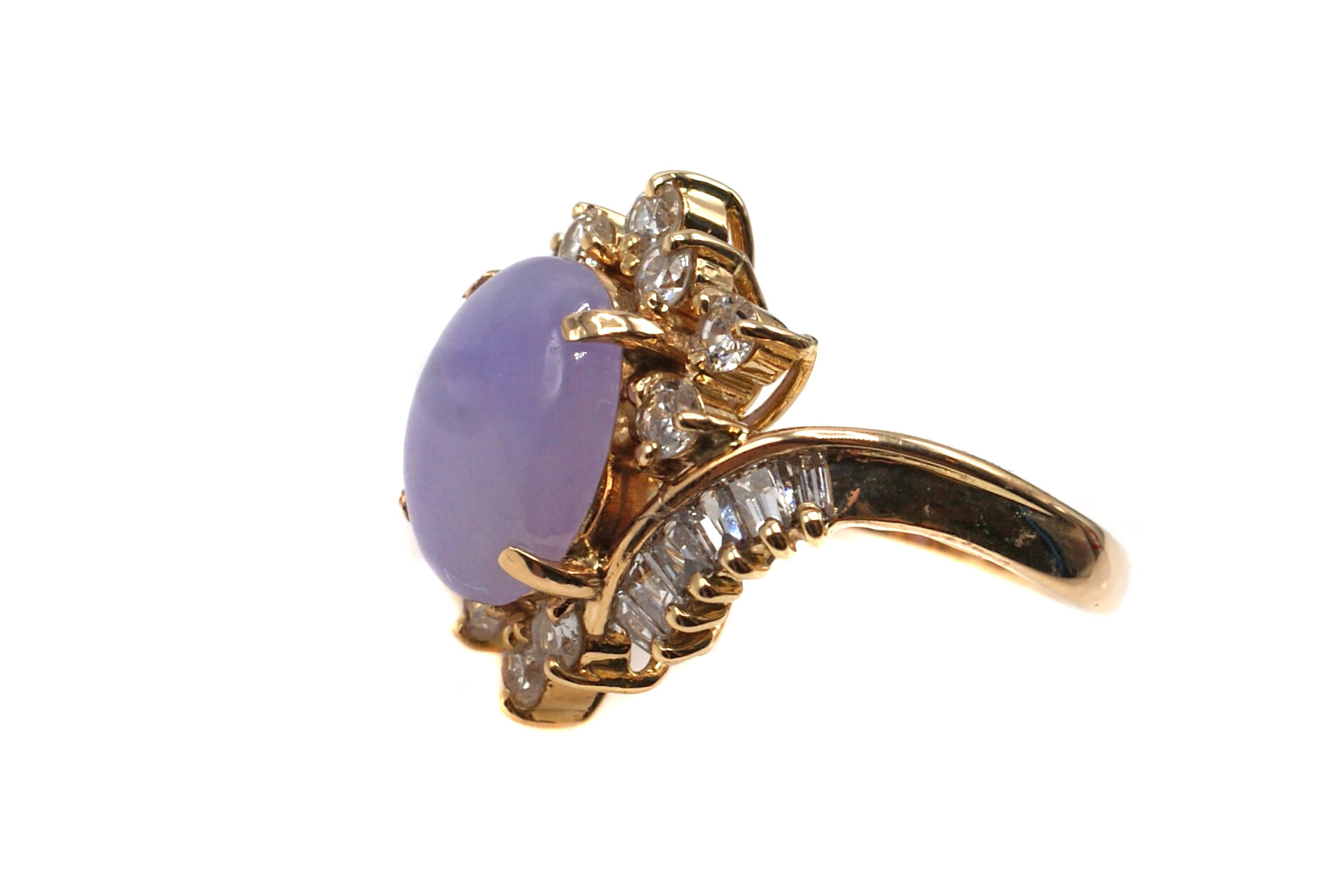 A beautiful lilac color oval lavender jade cabochon is centrally set in this well handcrafted 1960s ring. The jade is measured to weigh approximately 3 carats and  surrounding the jade are 10 bright white and sparkly round brilliant cut diamonds and