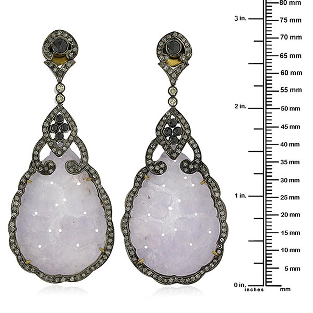 Pear Drop shape lovely Lavender Jade earrings with Diamonds in Gold and Silver. There is black and white diamond in this earring set in silver and gold.

Closure: Push Post

18k: 2gms
Diamond: 3.7ct
Slv: 11.39gm
Jade: 41.10ct