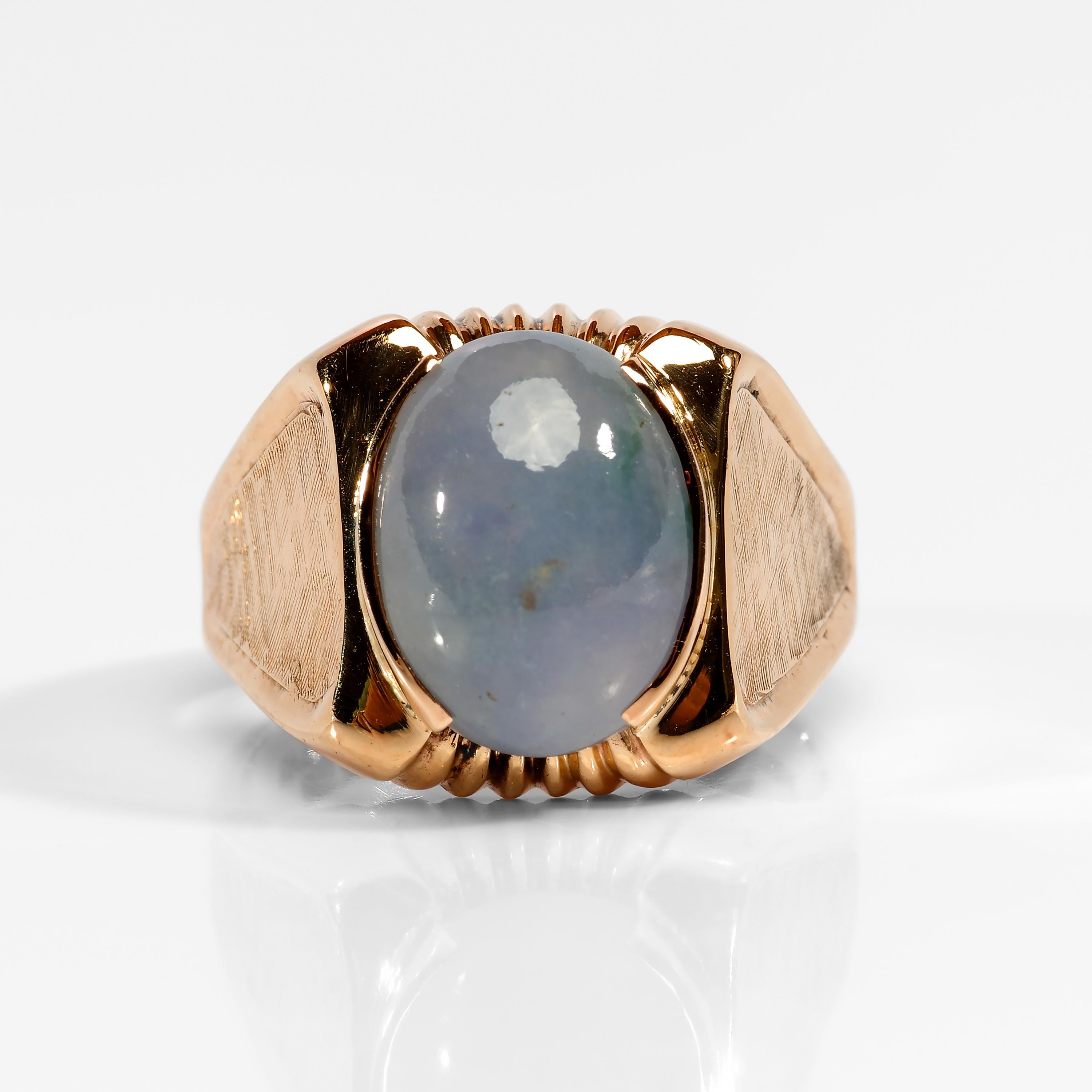 This Mid-Century men's ring was created in rosy red gold and showcases a beautiful lavender jadeite jade cabochon. The jade is a natural and untreated double cabochon with a beautiful translucency. There's a tiny sprig of green near one of the