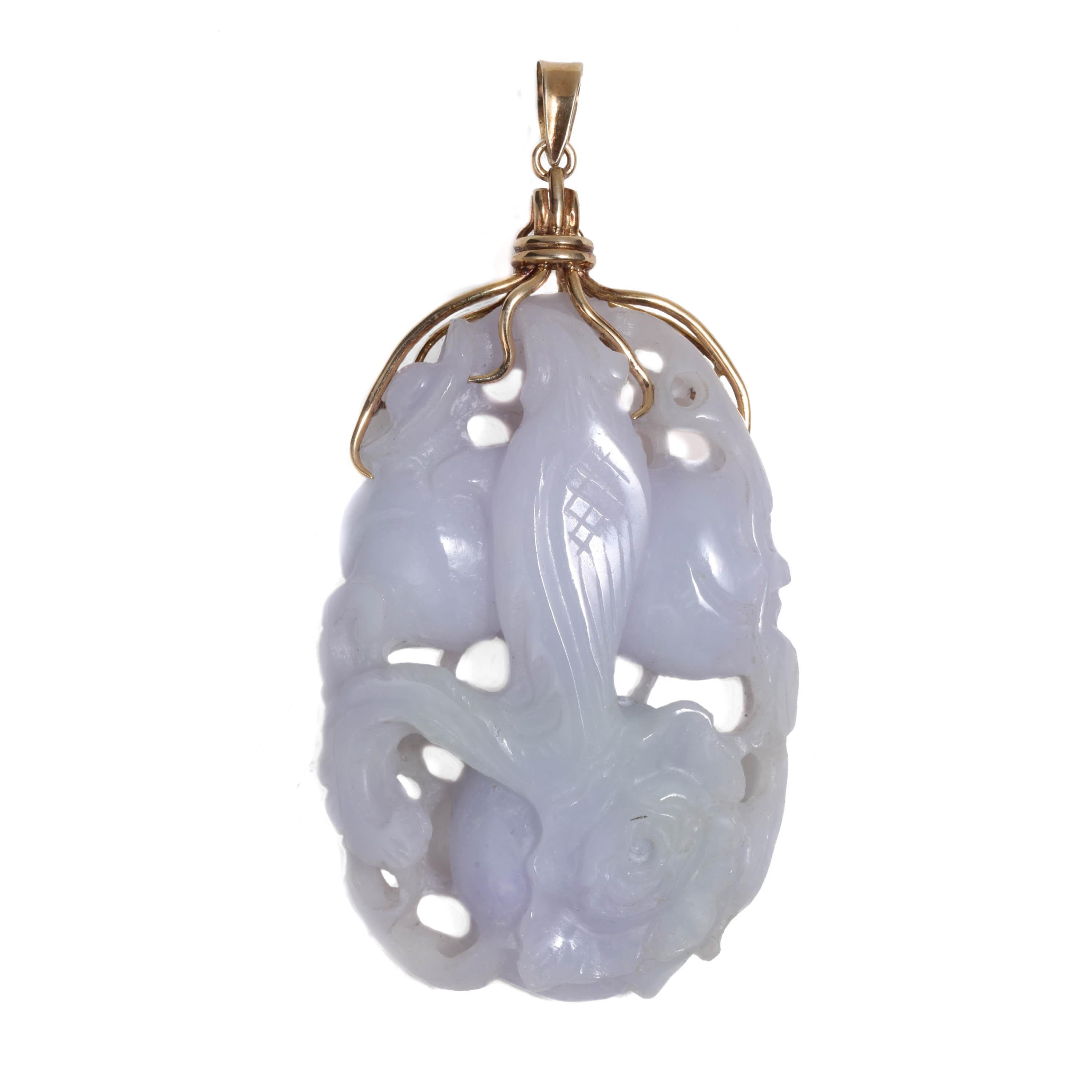 This circa 1950s natural and untreated jadeite pendant is a showcase of lapidary skill and artistry. The pale violet and light green stone has been carved and pierced, depicting a regal bird poised with fruit and flowers on one side, lacy vines on