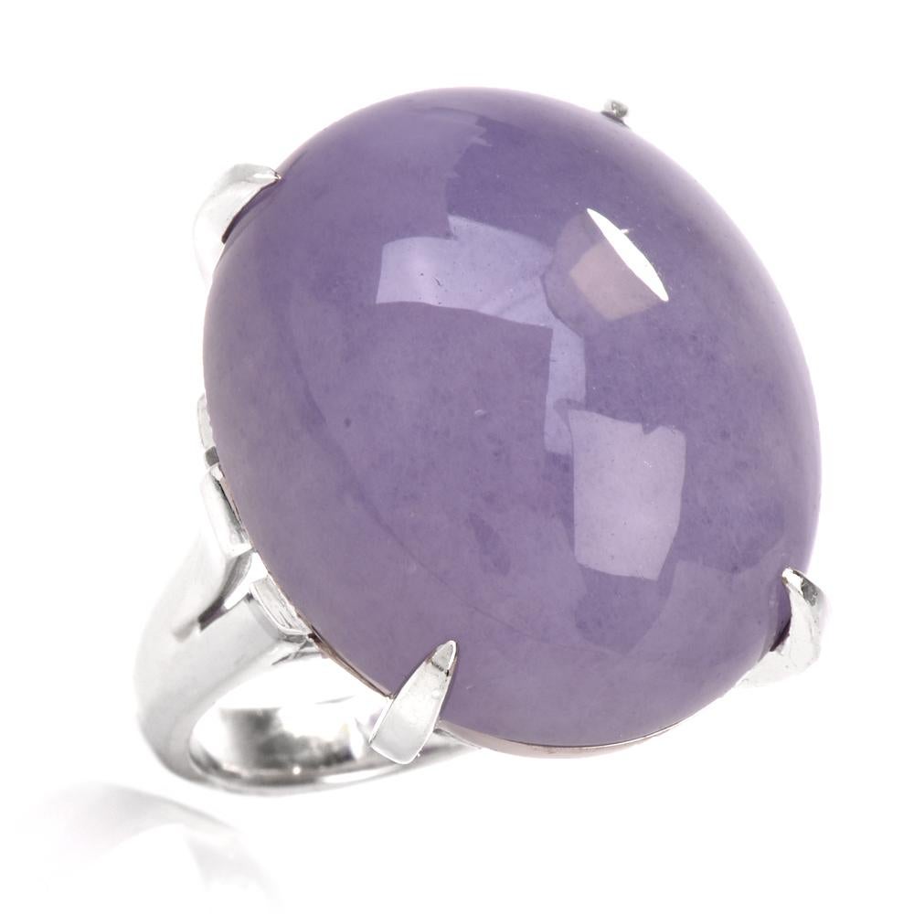 This amazing ring crafted in solid platinum exposes an eminent GIA lab reported, 40.28 carat lavender jade of an enchanting pastel lilac color, secured by 4 paw-prongs atop a highly ornate undercarriage. The ring's broad, triangular shoulders lead