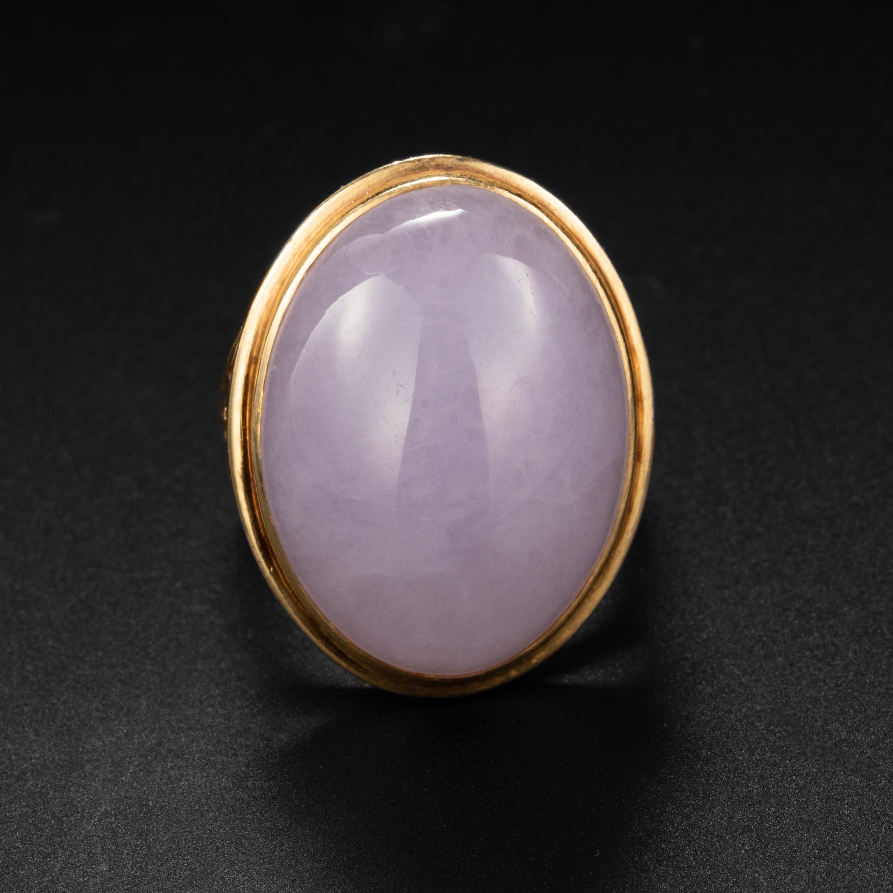 Created by the iconic Midcentury jeweler, Ming's of Hawaii, this entirely hand-fabricated ring in 14K yellow gold features a magnificent and luminous bright lavender oval cabochon of natural and untreated Burmese jadeite. The jade stone measures