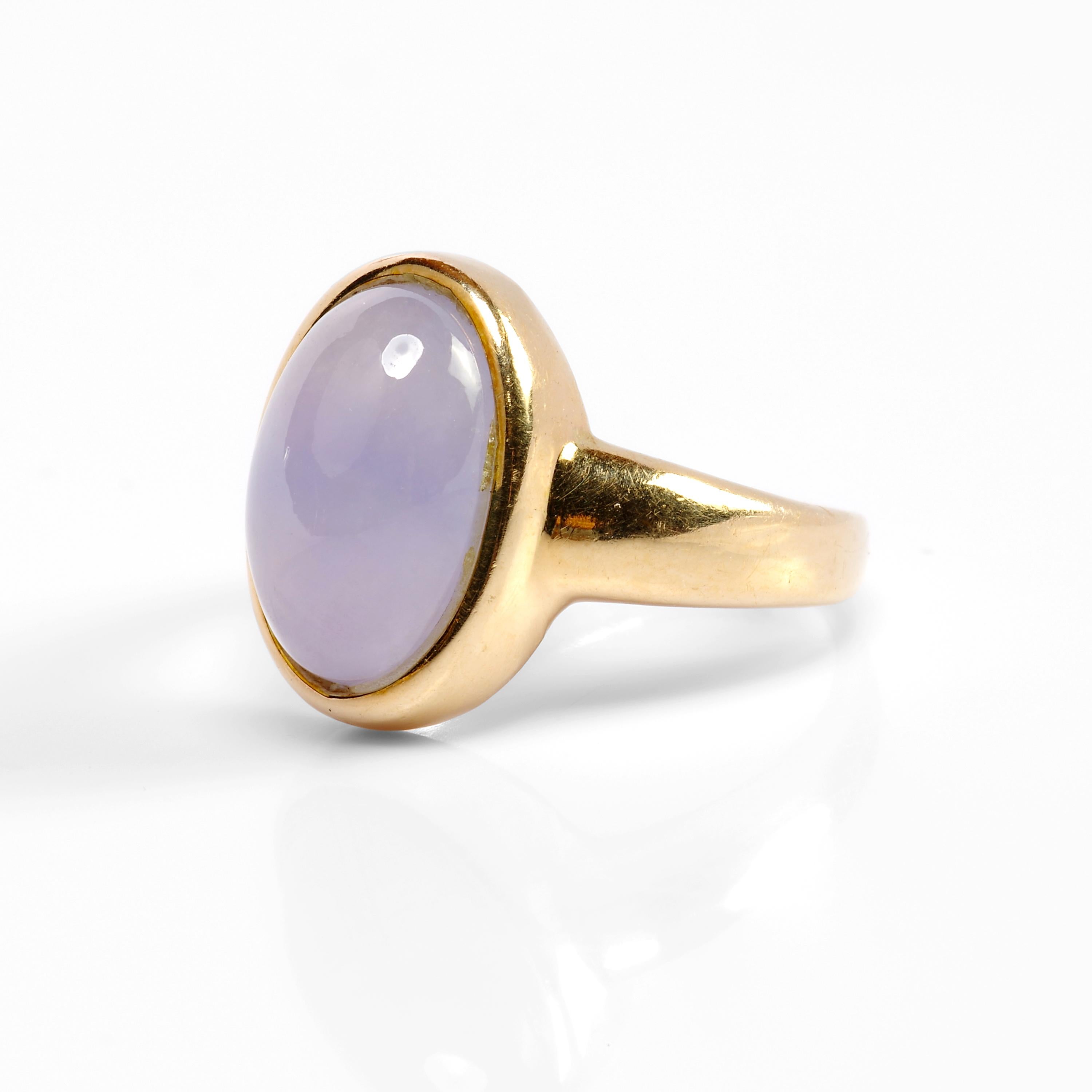 This small, sleek little ring is a Midcentury gem -literally. The 14K yellow gold band holds a lovely lavender jade double cabochon that is certified to be 100% natural and free of any dyes or polymers. The jade gem has excellent translucency and an