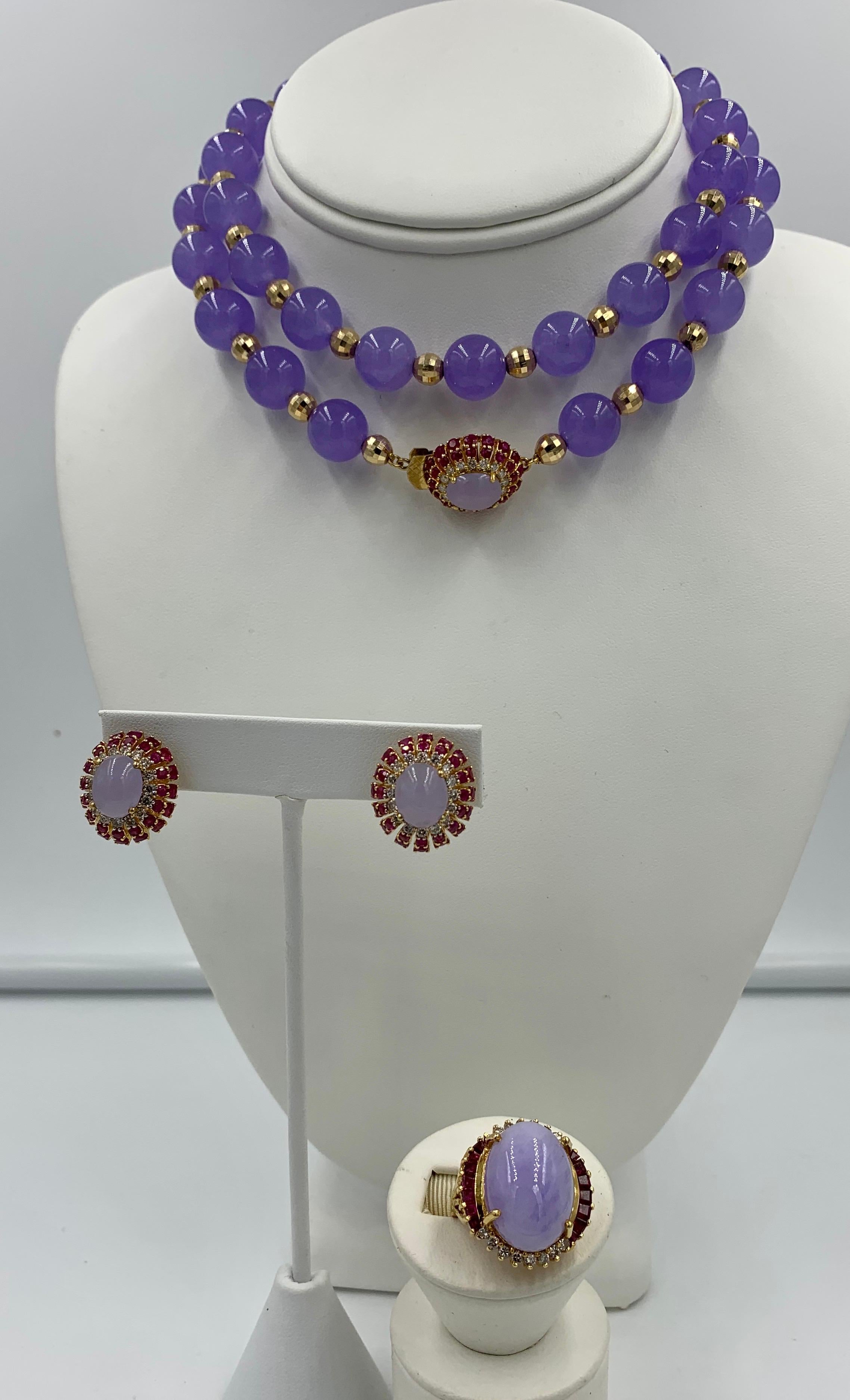 A spectacular Lavender Jade, Ruby, Diamond Suite.   The suite comprising a necklace, earrings and ring each with gorgeous Lavender Jade oval cabochons with a 17 Carat Jade Cabochon in the ring.  The Jade cabochons are surrounded by 1.25 Carats of