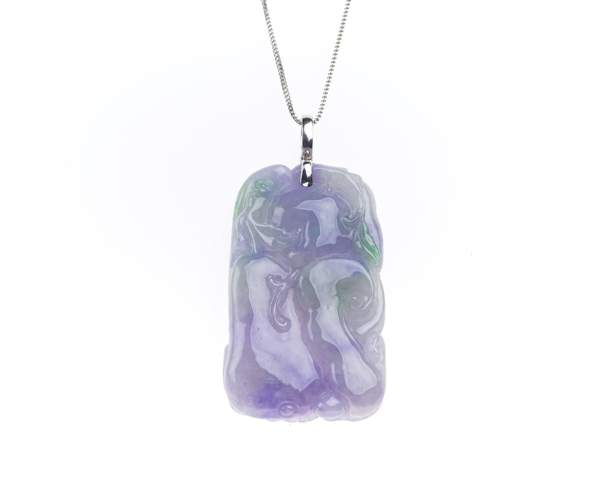 This all natural, untreated lavender jadeite jade carved blooming peony flower and peaches has a hint of green. The carving of the peony flower symbolizes fortune and wealth while the peaches symbolize longevity. 

It measures 1.26 inches (32.1mm) x