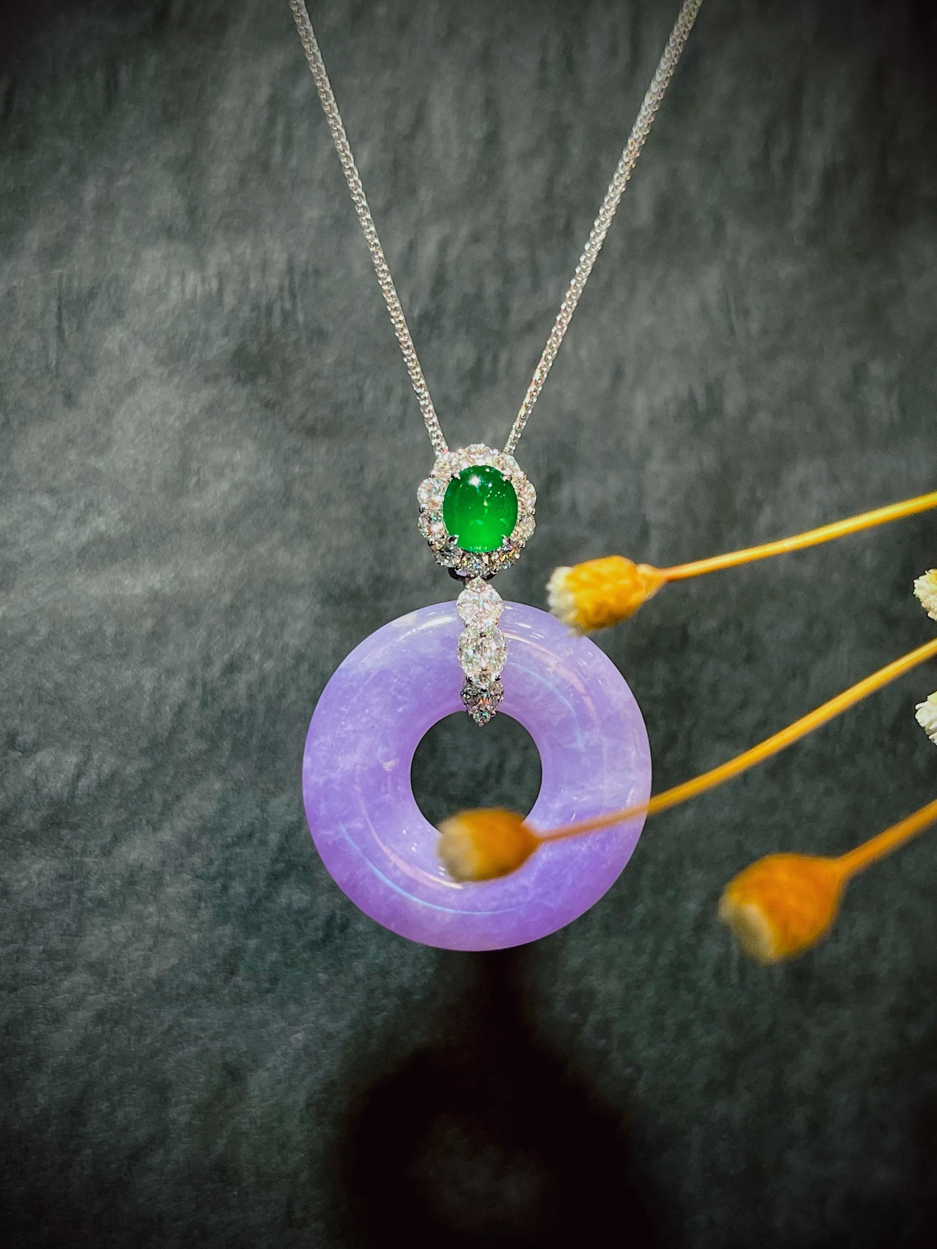 Un magnifico pendente di giadeite naturale (fei cui) composto da un cerchio di giadeite lavanda dalla struttura fine e da un cabochon di giadeite verde smeraldo altamente traslucido, decorato con diamanti rotondi taglio brillante per un totale di
