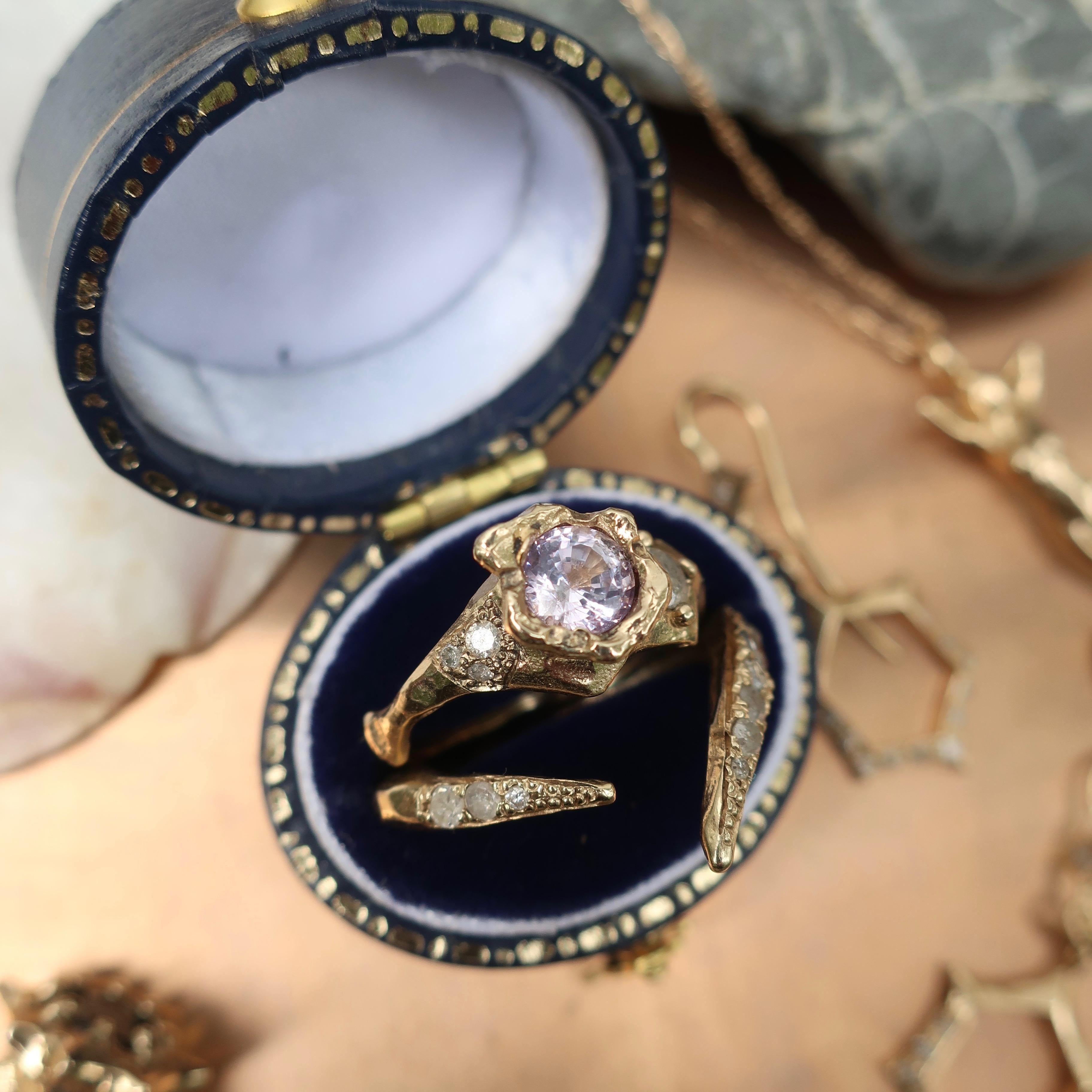 This hand carved ring cast in 14K yellow gold showcases a beautiful 5mm lavender sapphire and asymmetrical band with pave diamonds. 

 

Size 6.25

