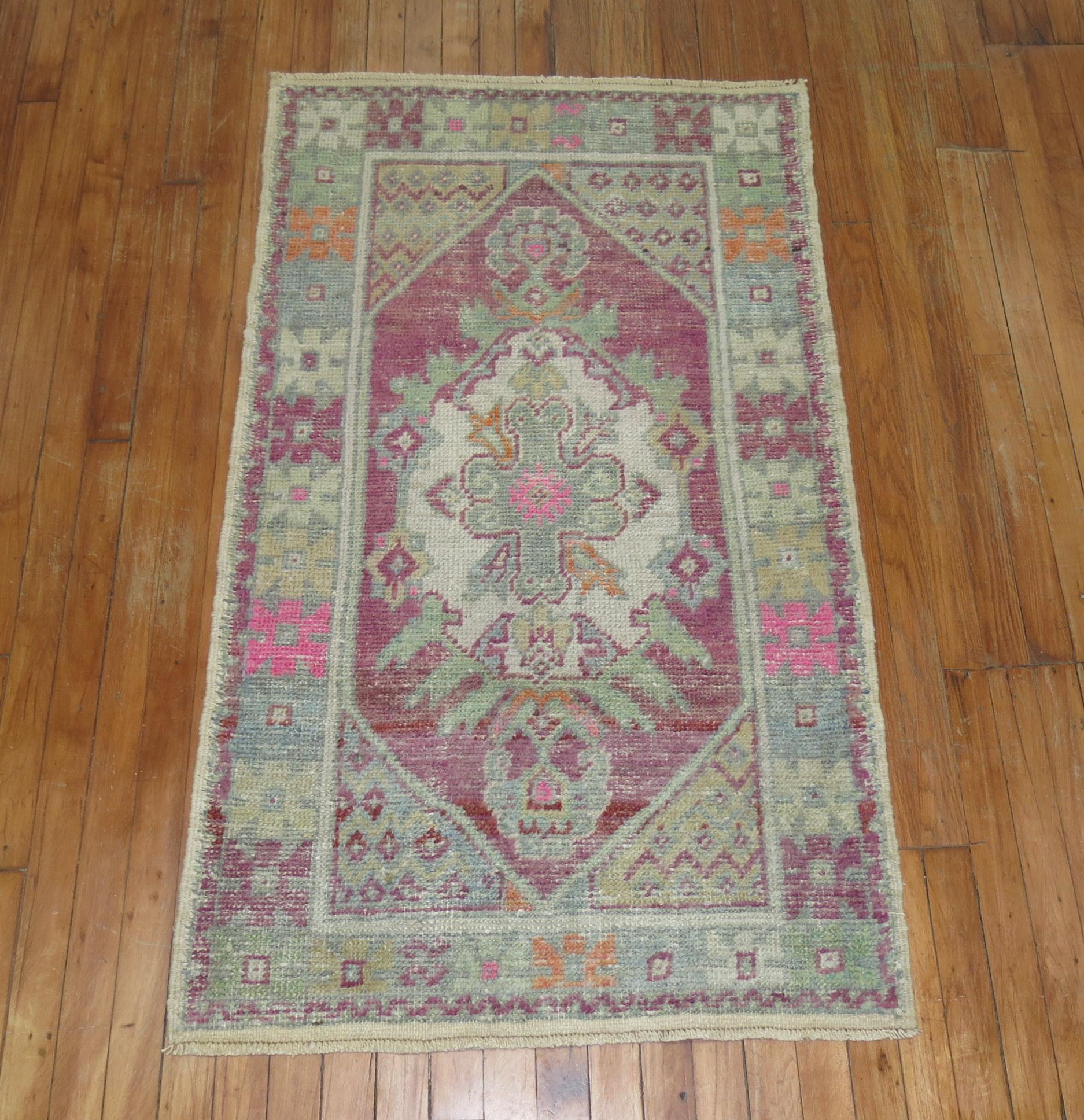 A pair of mid-20th century Turkish Anatolian rug mats with a lavender field pops of green and pink accents. One piece is 1 inch wider than the other.

2'8