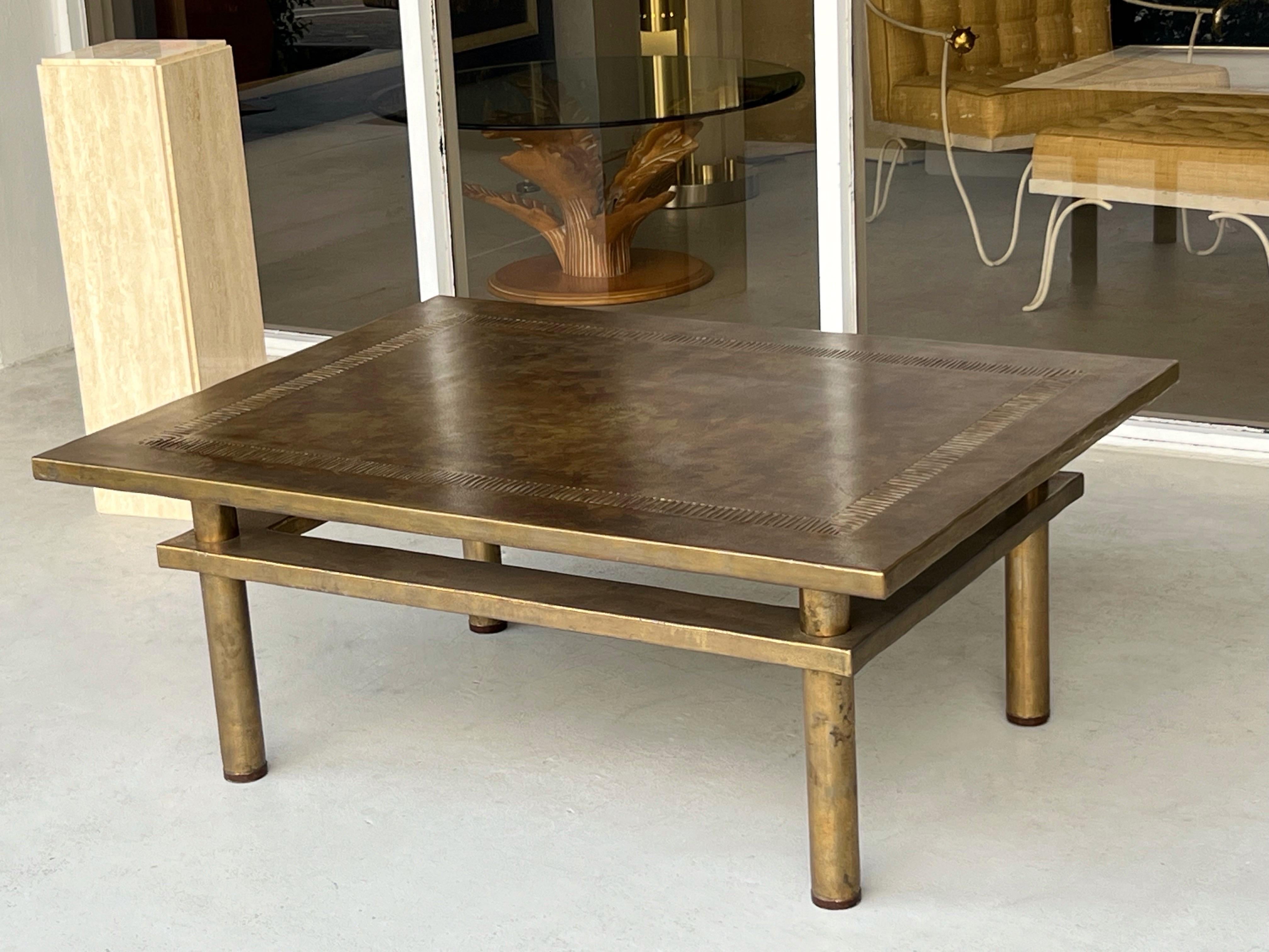 A well proportioned coffee table. The legs are bronze with a patinated bronze clad top. The top has subtle uneven edges, and an intaglio design on the perimeter. Beautiful patina.