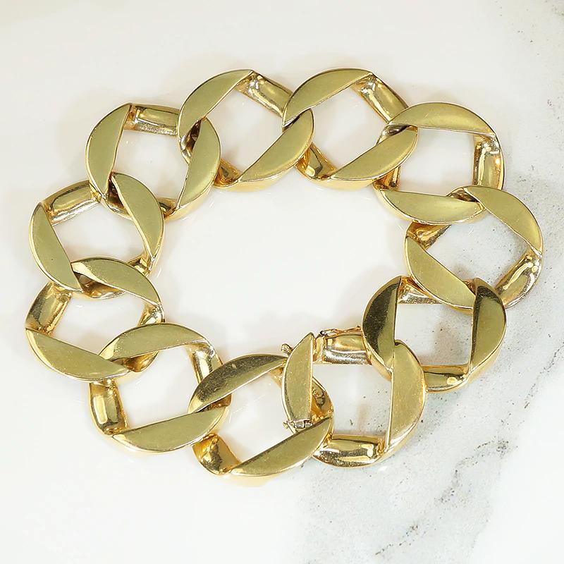 Lavish Mid Century Modern bracelet of heavy gold links. The oversized 14k yellow gold links are a kind of loose curb; swanky, with a refined industrial vibe. The bracelet is smooth and supple with a satisfying weight. The bracelet secures with a