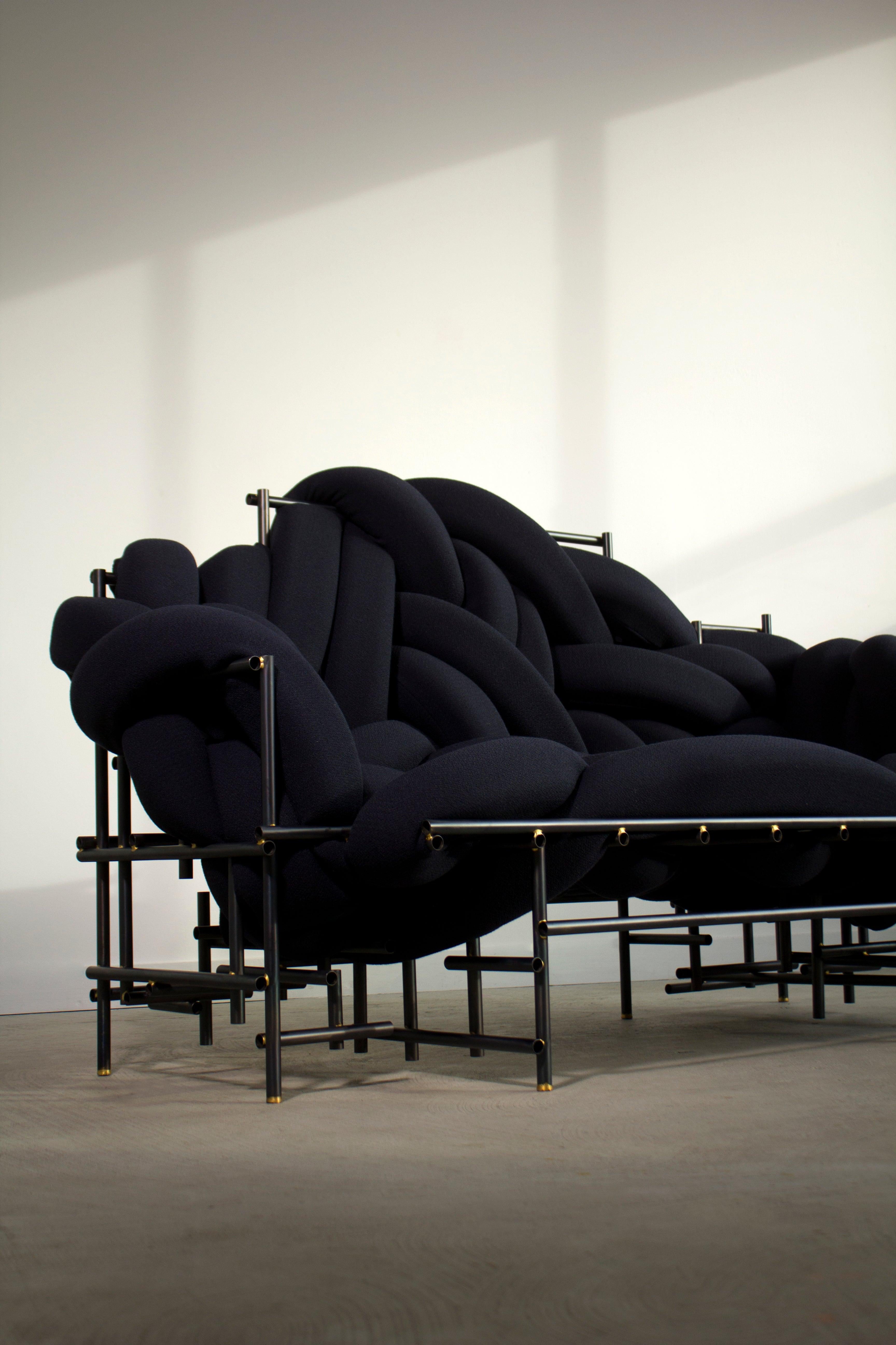 Lawless sofa by Evan Fay.
Each is a unique hand-sculpted creation. 
Dimensions:
W 1676, D 863, H 1016 mm
W 66”, D 34”, H 40” inches (can be made to order in other dimensions).
Materials: steel, brass, foam, knoll stretch appeal upholstery