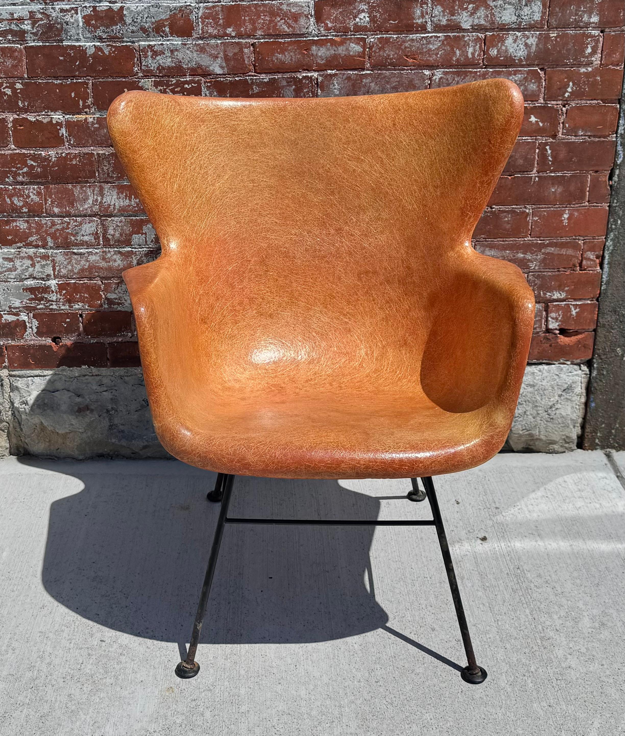 Classic Modernist Design. Lawrence Peabody fiberglass arm lounge chair. Nice shade of burnt orange with the more desirable wrought iron black base. Comfortable with a high back. Exposed black bushings visible from behind. Eames Technology used on a