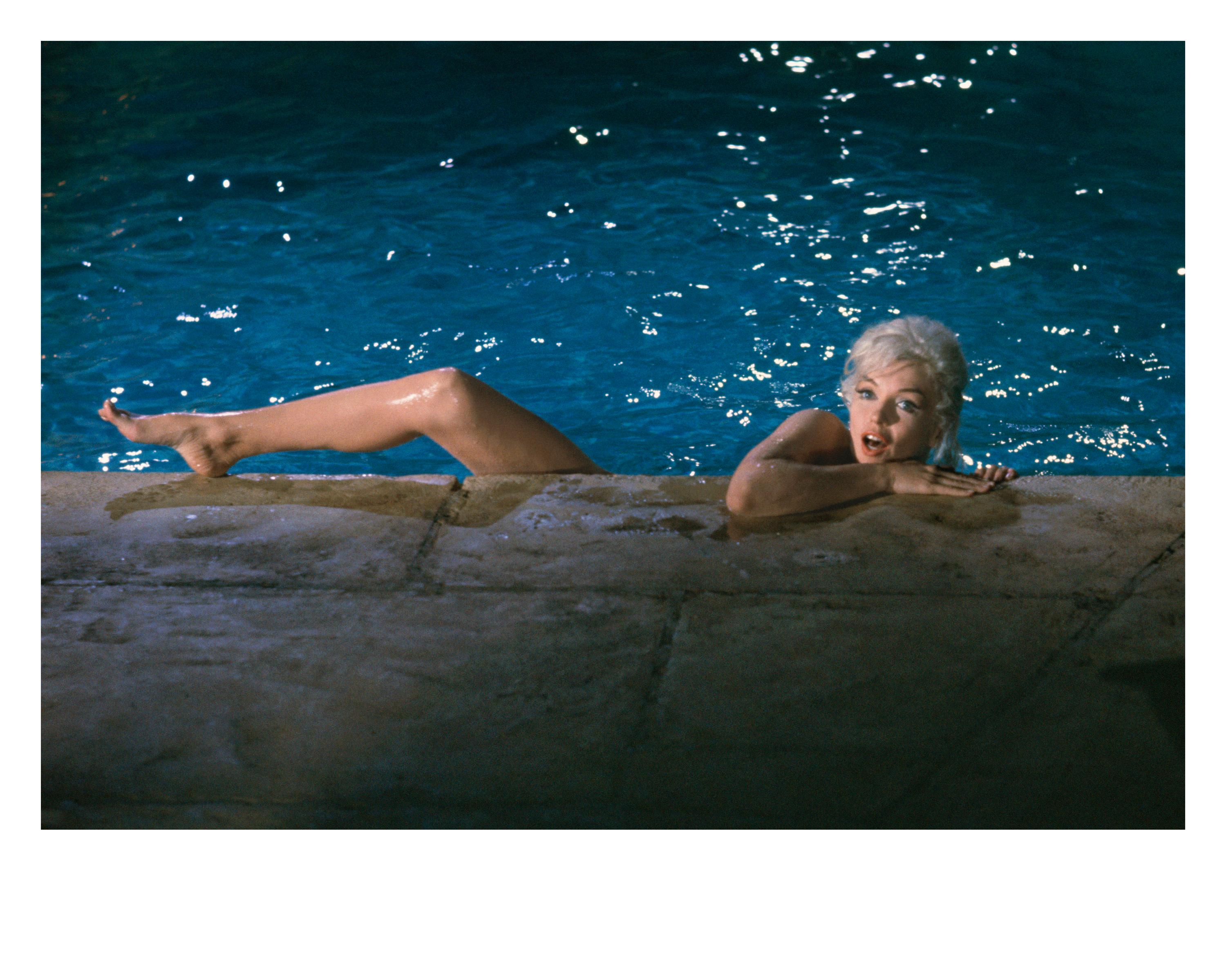'Marilyn Monroe, 1962' by American photographer, Lawrence Schiller. Digital pigment, Ed. of 35. Image: 13 x 18.5 in. / Paper: 16 x 20 in. From the set of the film 'Something's Got to Give', this colored photograph features Marilyn Monroe in a pool