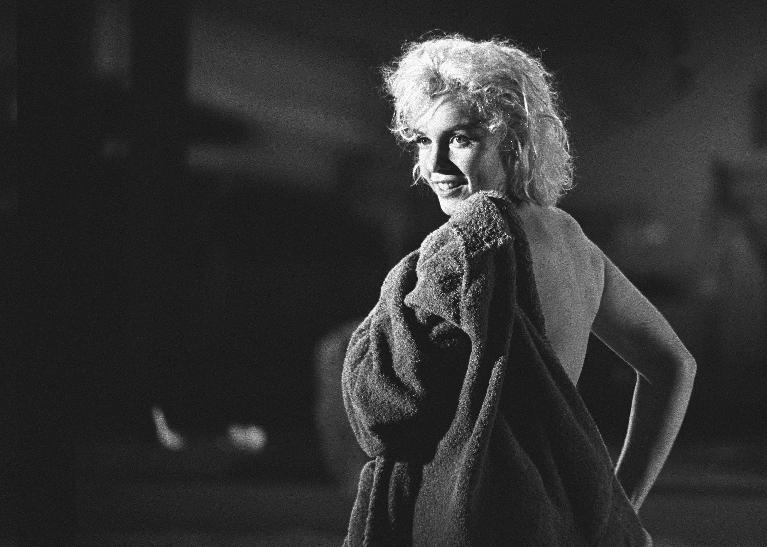 Lawrence Schiller Portrait Photograph - Marilyn Monroe Photograph Putting on a Robe, 24/75