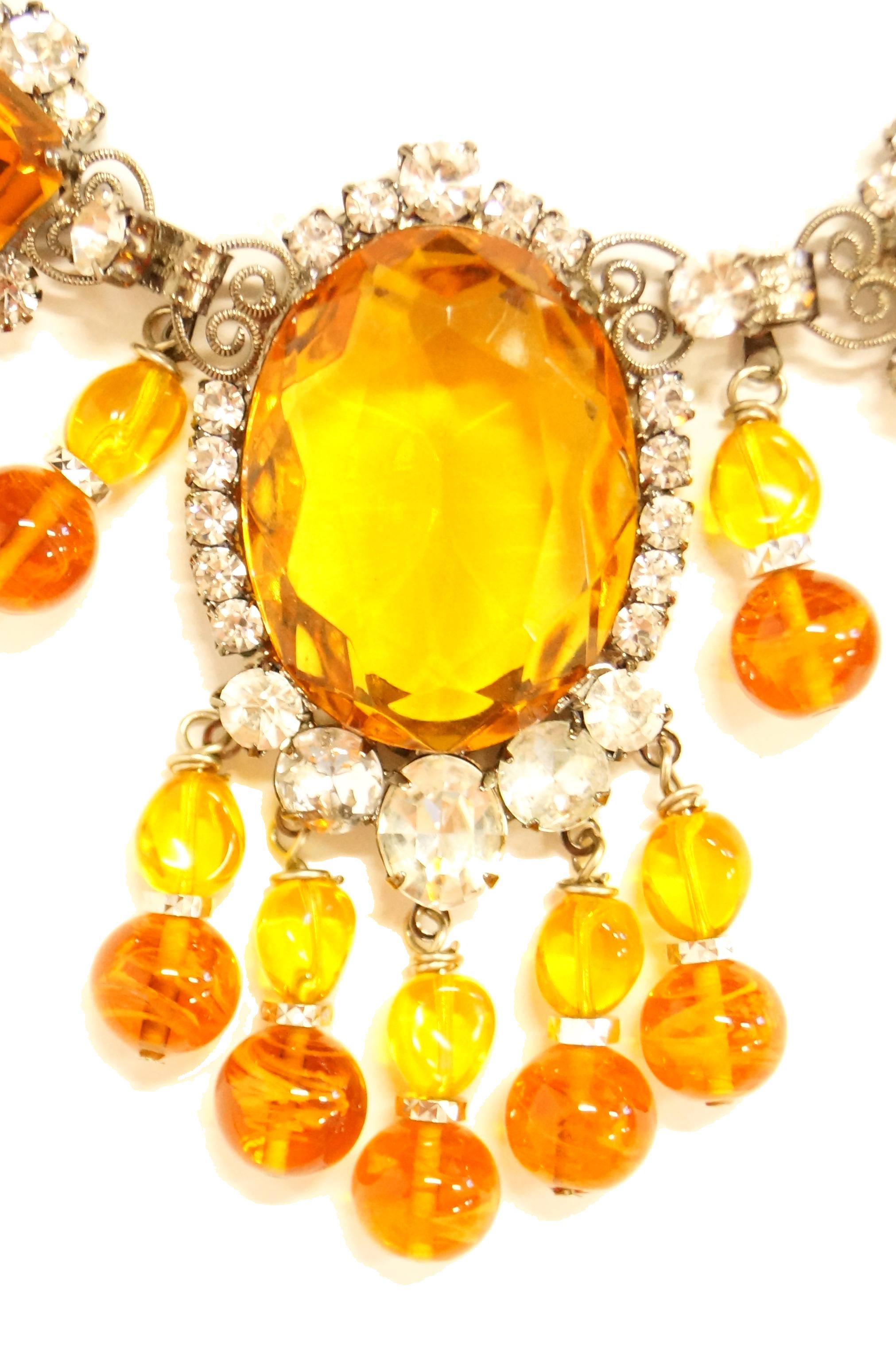 Gorgeous bright yellow necklace and earrings set by Lawrence Vrba! The oversized bib necklace is incredible, and features a brilliant oversized oval cut crystal center bordered by small clear multifaceted rhinestones. The top of the oval features a