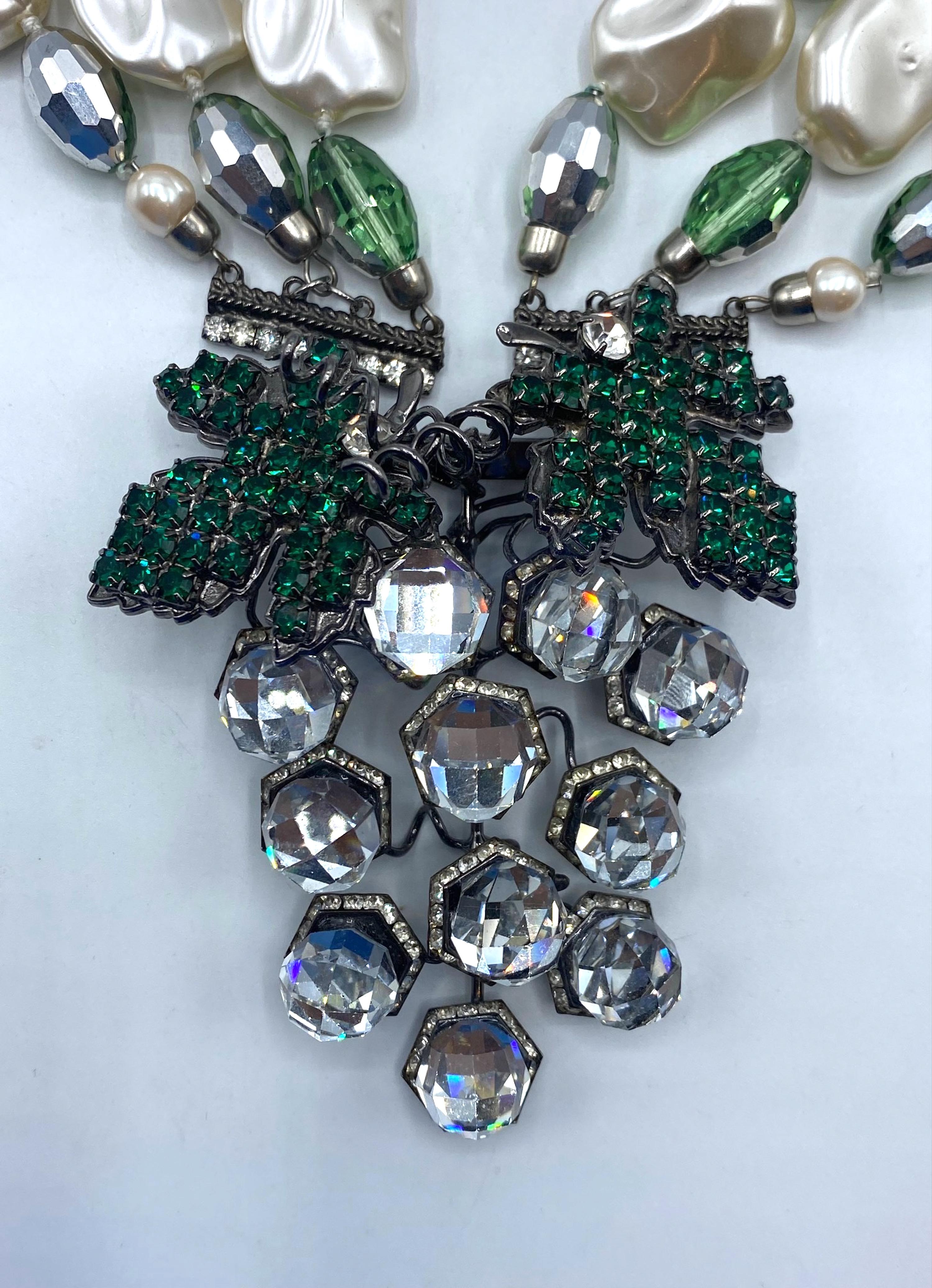 Questa descrizione dettagliata mette in evidenza una collana di perle d'acqua dolce finto-barocca di Lawrence Vrba a tre fili, ornata da perline oblunghe in argento e verde smeraldo con taglio briolette. La collana si distingue per la spilla a