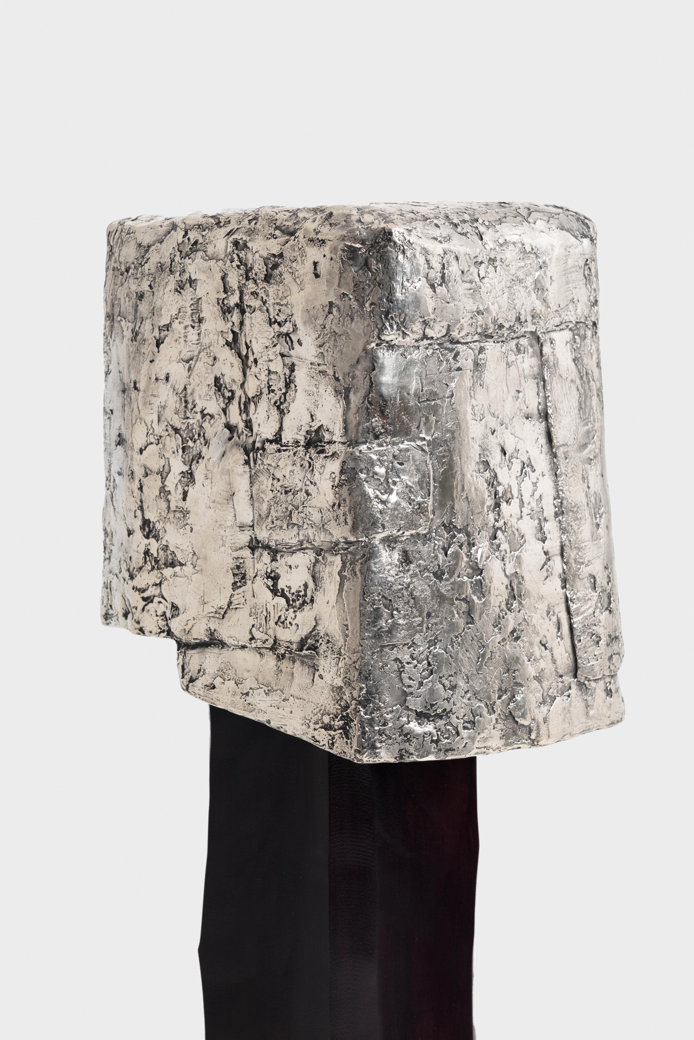 The Floor Light, materialized in white bronze, shows a relief of solidifying wax
in which textile is dipped, then draped, in a fixed position. It is by placing layer
over layer, how slowly strength is increasing within the model. 

The series tells