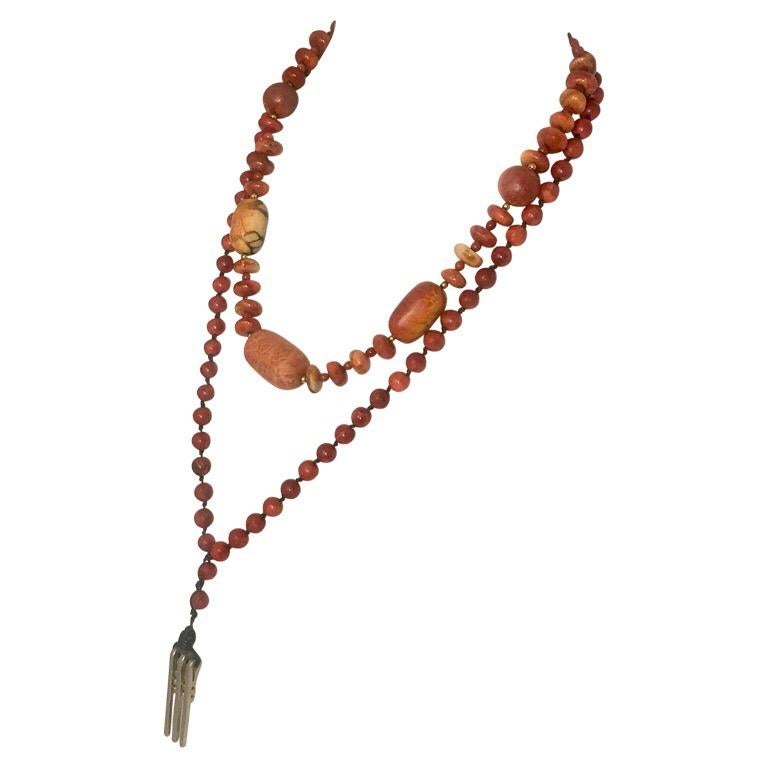 This layered necklace set consists of apple and  red coral beads as well as an art deco sterling pendant. The shorter, inner necklace has 5 large oval beads.The large beads are apple coral separated by 36 small red coral beads with 24 gold vermeil