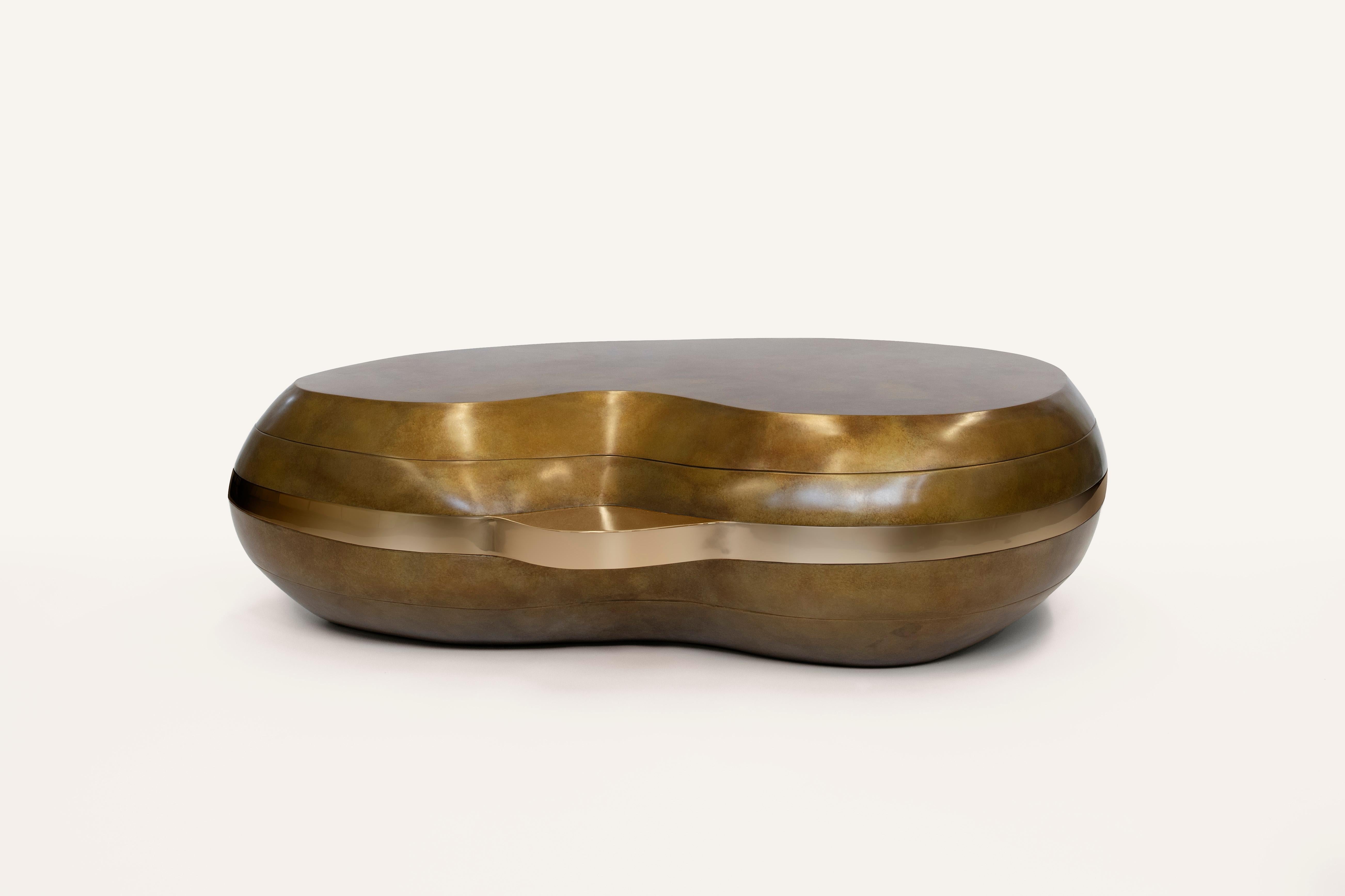 Der Layered Couchtisch ist Teil unserer Stone Collection und wurde von den weichen Kurven und ausgeprägten Schichten von Trommelsteinen aus dem Meer inspiriert. Dieser Tisch zeigt sorgfältig von Hand modellierte, konvexe Schichten aus Bronze mit