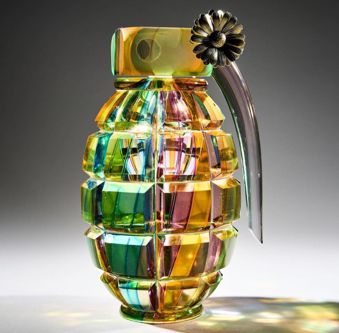 Layne Rowe, Rainbow Grenade, 2023

Hot sculpted glass, cut polished and assembled with solid gold daisy

H14 x W7.5 x D6.5cm

A seductive and vulnerable material, glass translates a potentially harmful object into a beautifully fragile art form.