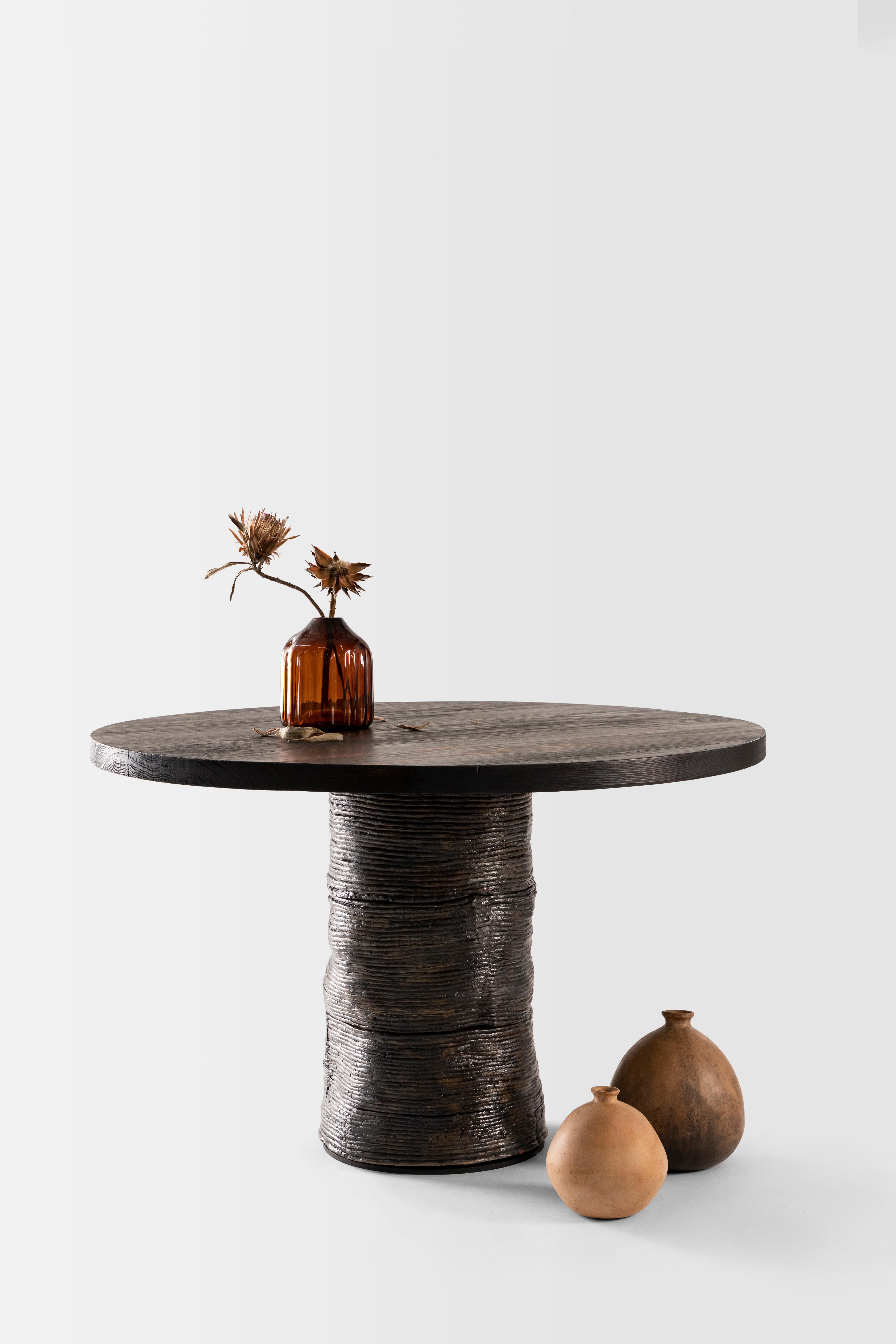 An homage to nature’s infinite cycles, the Lazo table contrasts a fired wood top and copperdusted terracotta coil sculpted base in a conversation piece in
its purest form. The name Lazo, meaning bond in Spanish, manifests in an interaction of those