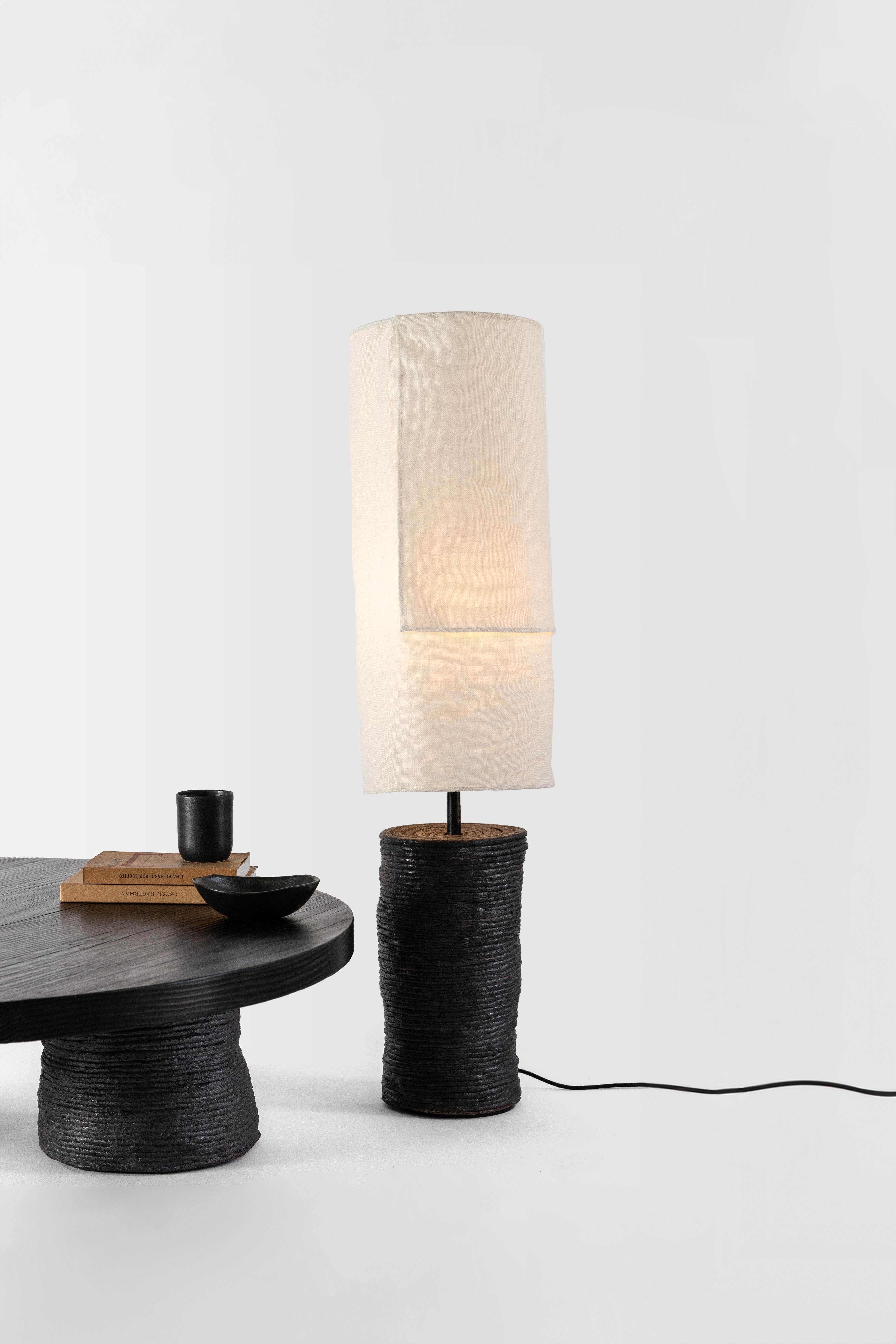 Nuanced craftsmanship shapes the pieces of the Lazo collection. A traditional Japanese wood burning technique emphasizes the grain of the tables’ wood and soft spun fibers give the lamps their subtle texture. The pieces’ bases are the products of
