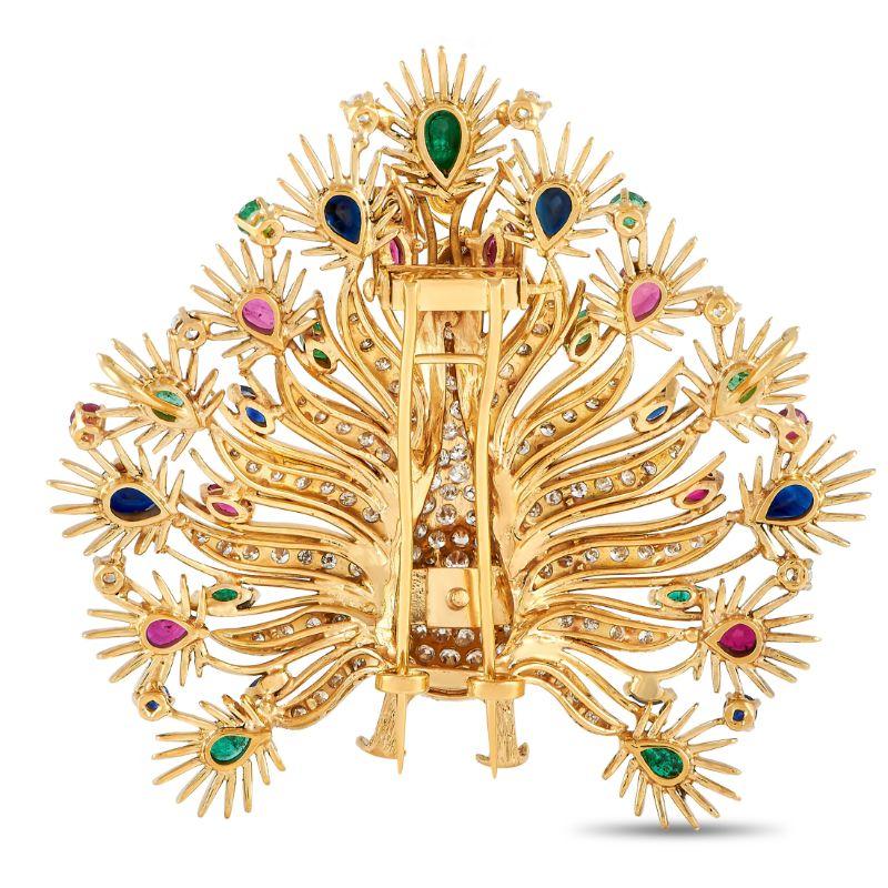 Bright and colorful yet elegant and refined, this multi-gem peacock brooch can certainly elevate the style of any ensemble. The 18K yellow gold sculpted bird from the pheasant family is dressed in diamonds and has its tail feathers adorned with