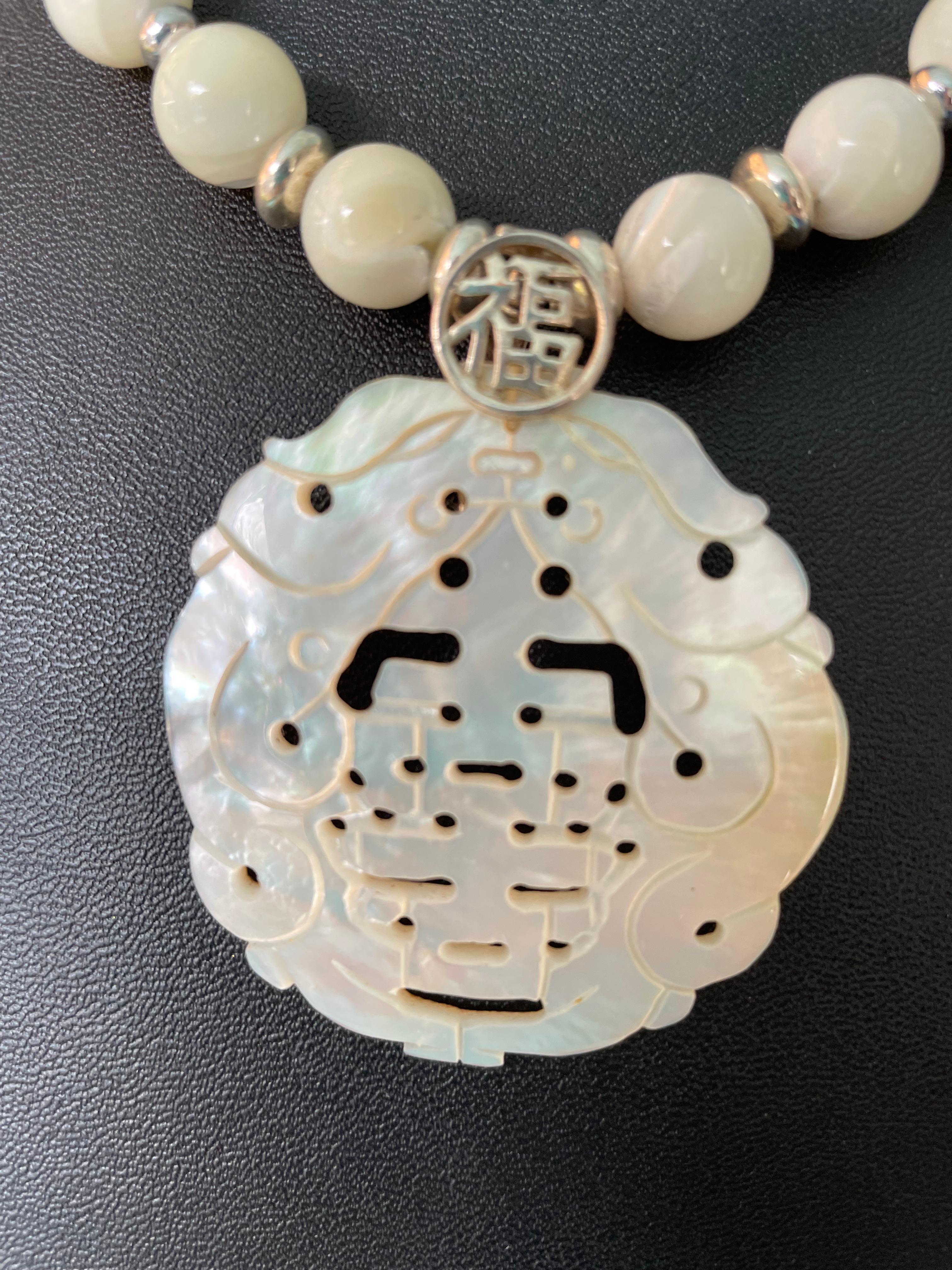 LB hand Carved Antique Chinese Mother of Pearl Happiness pendant is on offer. This lovely, delicate, stunning piece is sure to please. It has been carefully hand carved and incised to create depth and texture. The iridescence of the shell is amazing