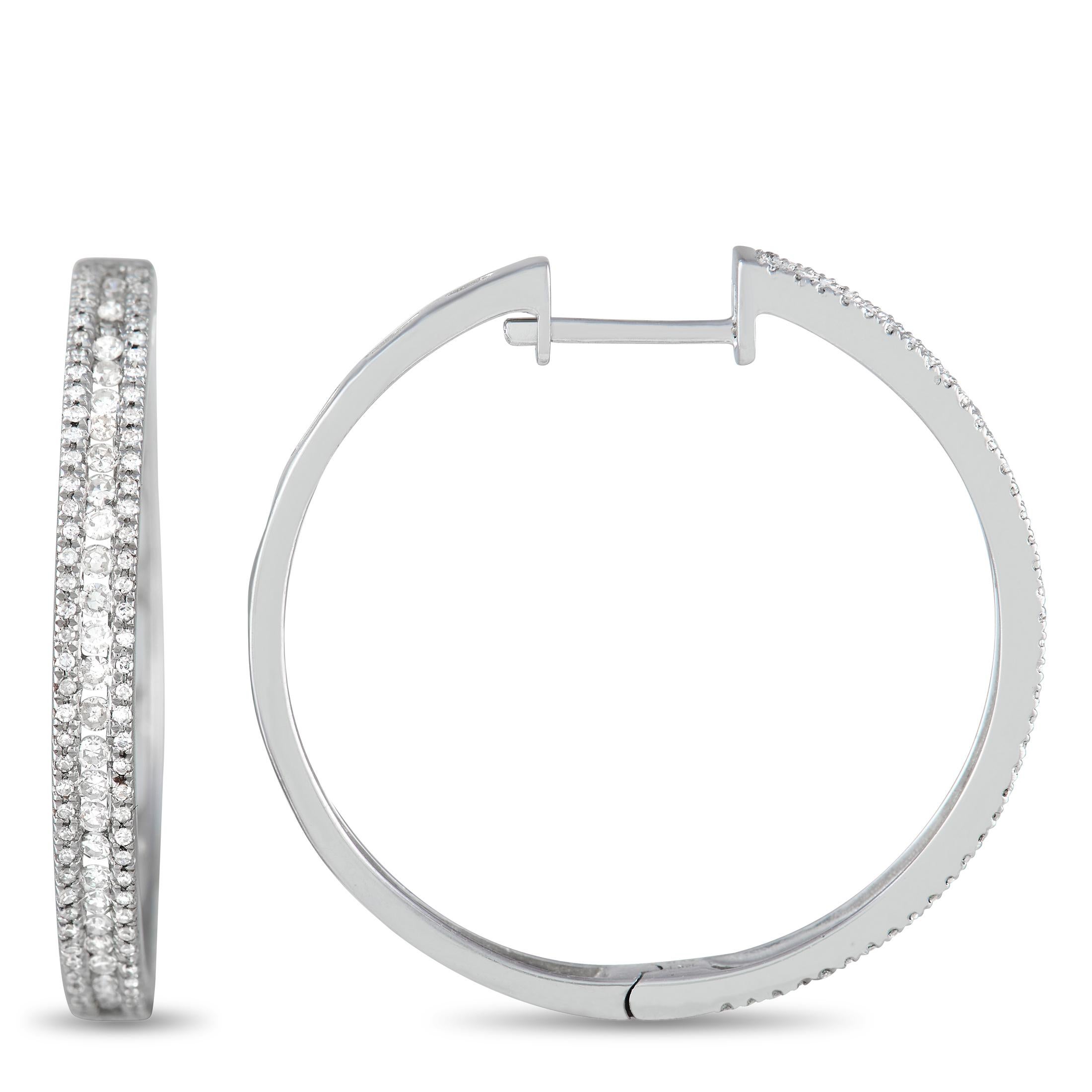 The prestigious sheen of 14K white gold and the alluring glisten of diamonds harmoniously combine into creating a wonderfully sophisticated sight in these stunning hoop earrings. The pair weighs 14.7 grams and the diamonds total 1.06 carats.
