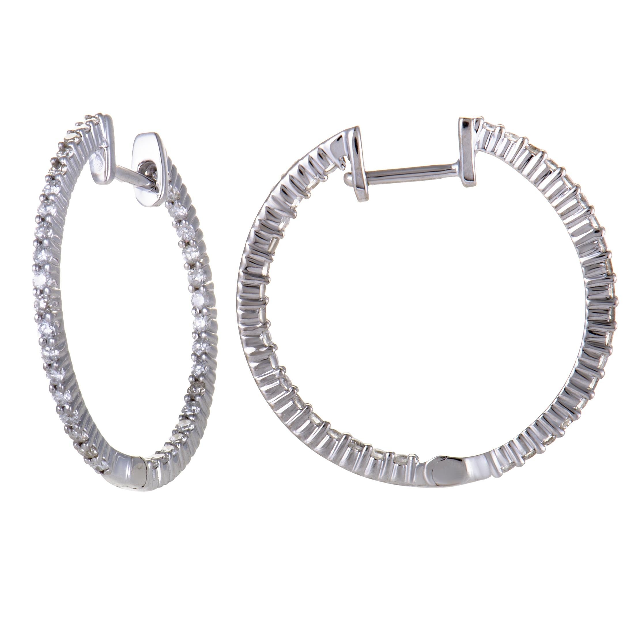 Subtle, understated design and glistening diamond embellishment are combined in these delightful hoop earrings. The pair is made of elegant 14K white gold and set with a total of 0.75 carats of diamonds.
