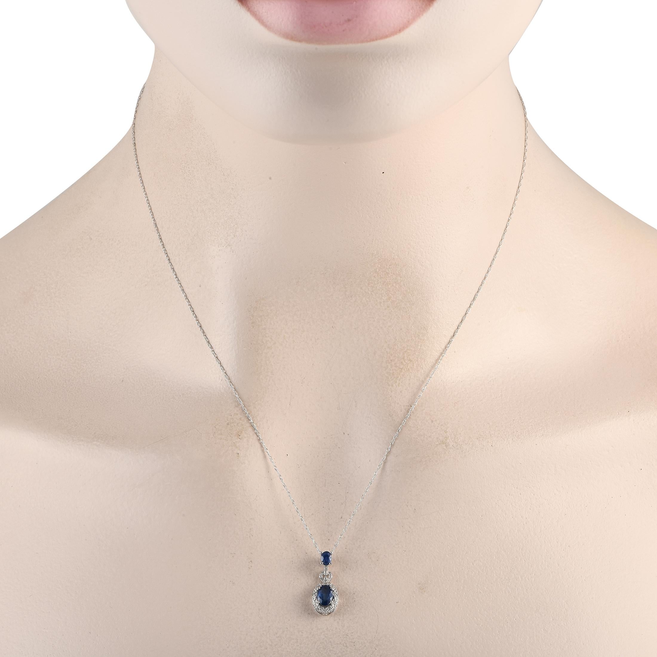 A pair of deep blue sapphire gemstones add a pop of color to this impressive luxury necklace. Simple and understated in design, this elegant accessory features an intricate 14K white gold pendant measuring 0.75 long by 0.25 wide suspended from an 18