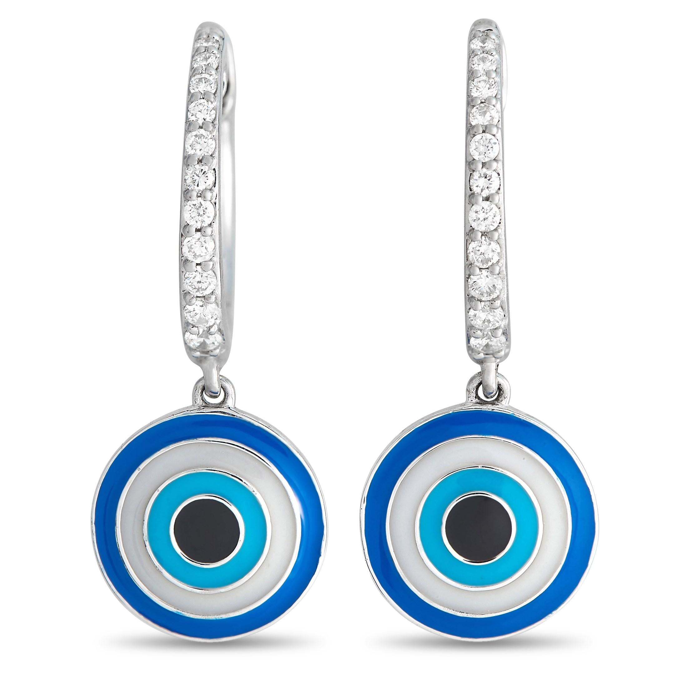 Keep the bad vibes at bay with this pair of sparkling diamond earrings with an evil eye accent. The 14K white gold huggie earrings have their front face lined with diamonds. Dropping softly from each huggie is a round evil-eye-inspired dangler in