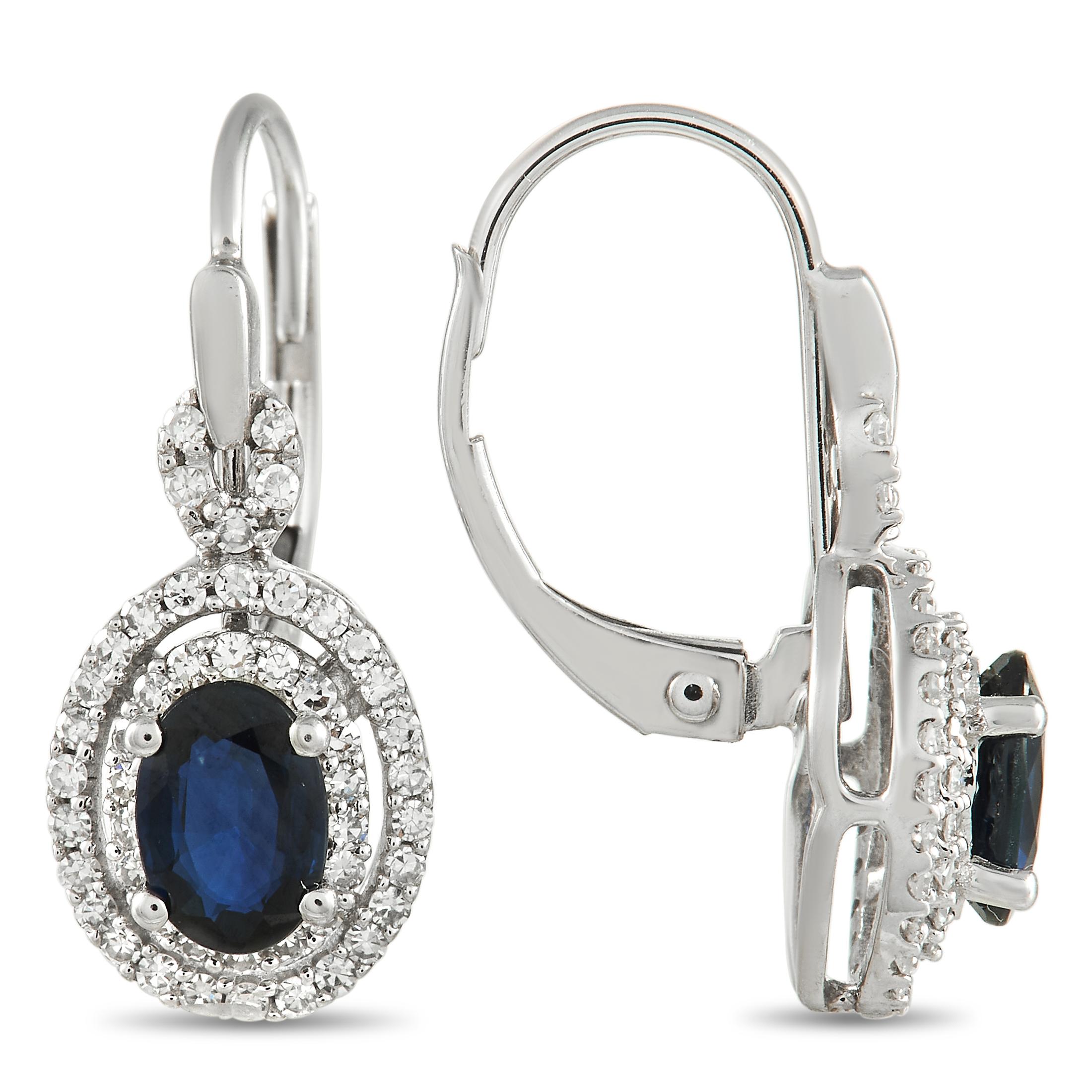 Crafted with a sleek 14K White Gold setting, these exquisite earrings are poised to continually take your breath away. At the center of a double halo of diamonds, oval-cut sapphire gemstones add a touch of extra elegance. These earrings measure