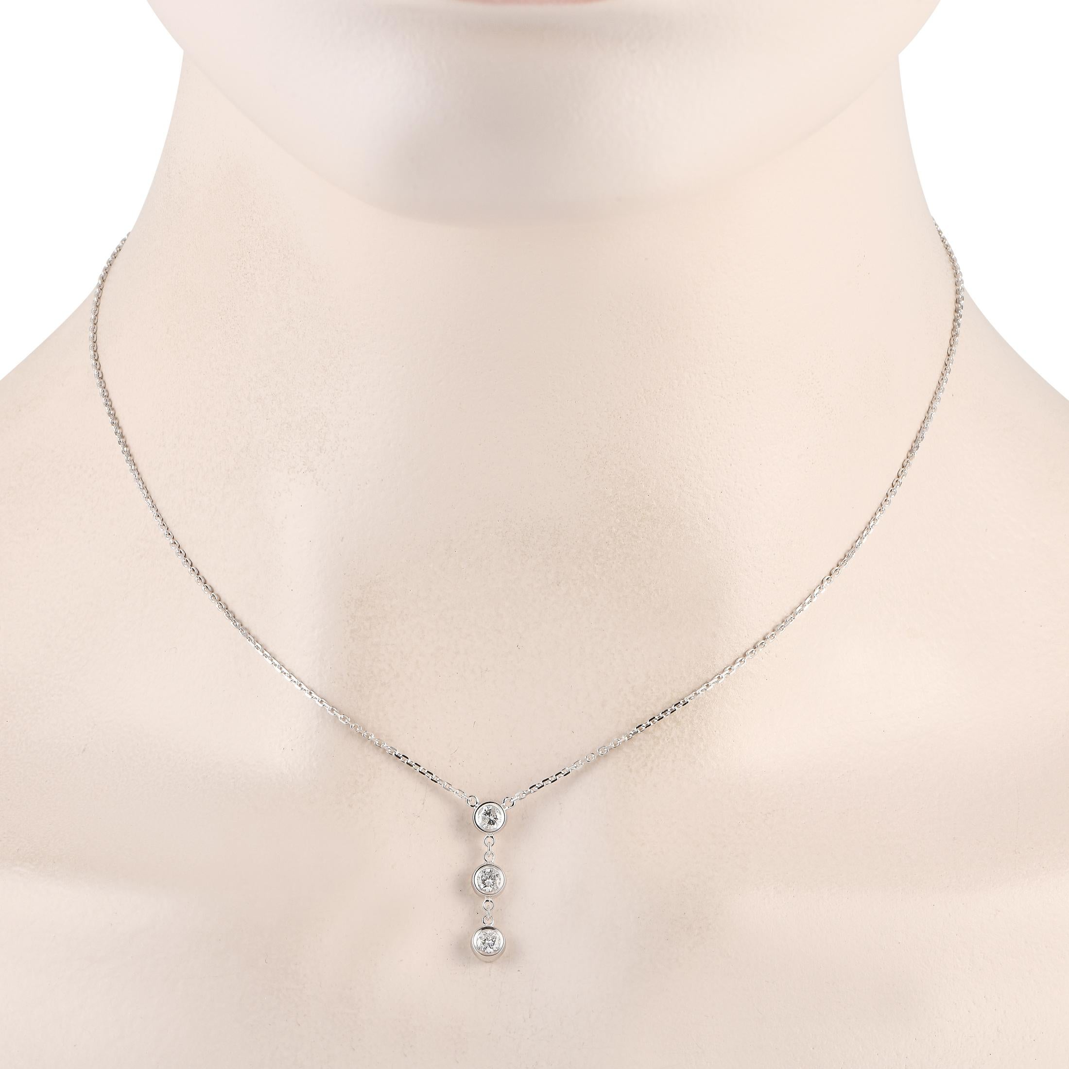 Make your everyday style sparkle with this three-stone diamond necklace. This 14K white gold necklace features a diamond trio pendant with three round bezel-set diamonds suspended vertically from a dainty chain. A lobster clasp secures the necklace
