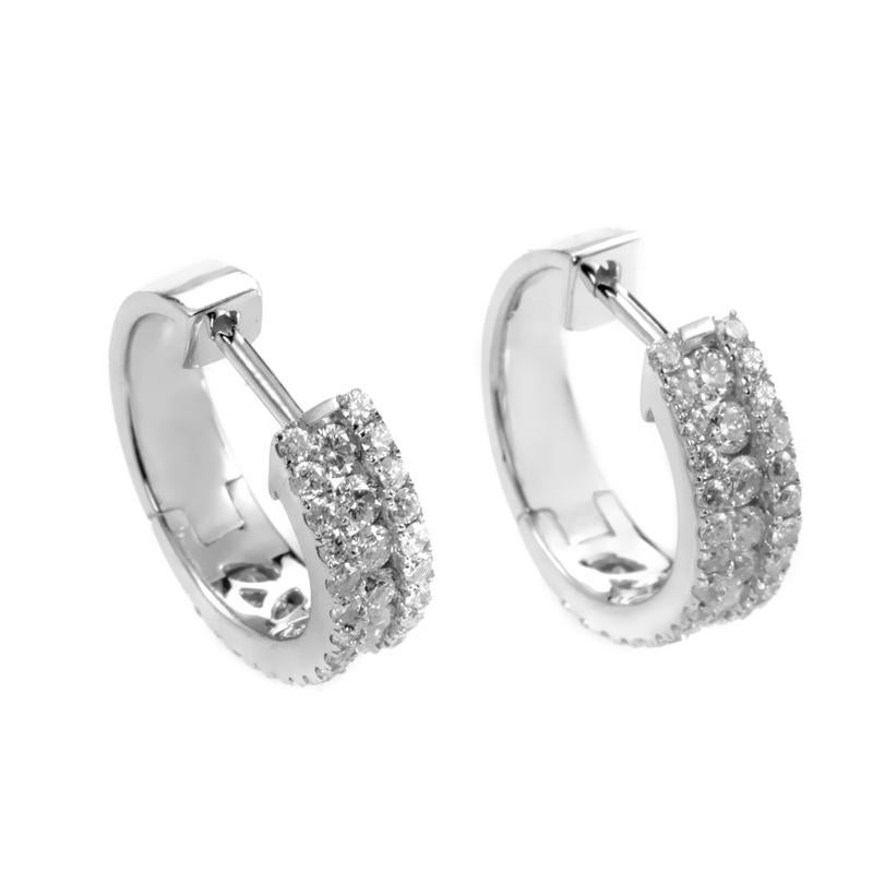 This pair of huggie earrings glisten with elegance and delicate diamonds. The earrings are made of 14K white gold and are set with 1.00 carats of diamonds.
