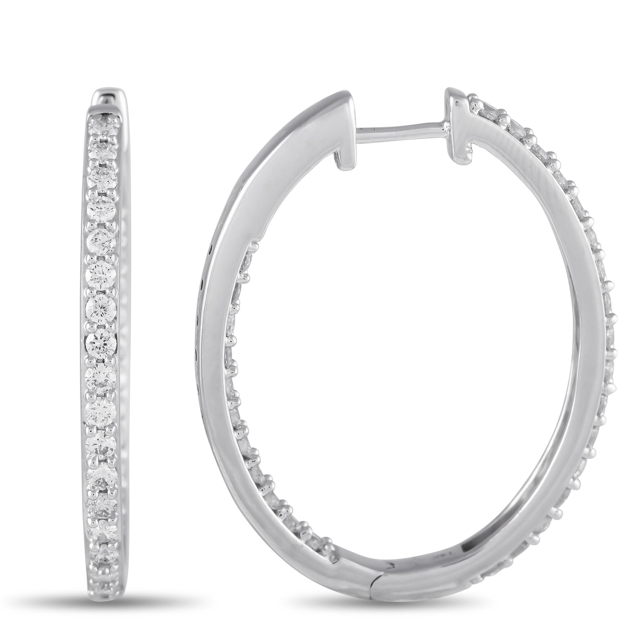 These 14K white gold hoop earrings are simple and statement. Each one features a sleek, minimalist setting that measures 1.25 long by 1.0 wide. Diamonds with a total weight of 1.50 carats allow them to effortlessly catch the light.This jewelry piece