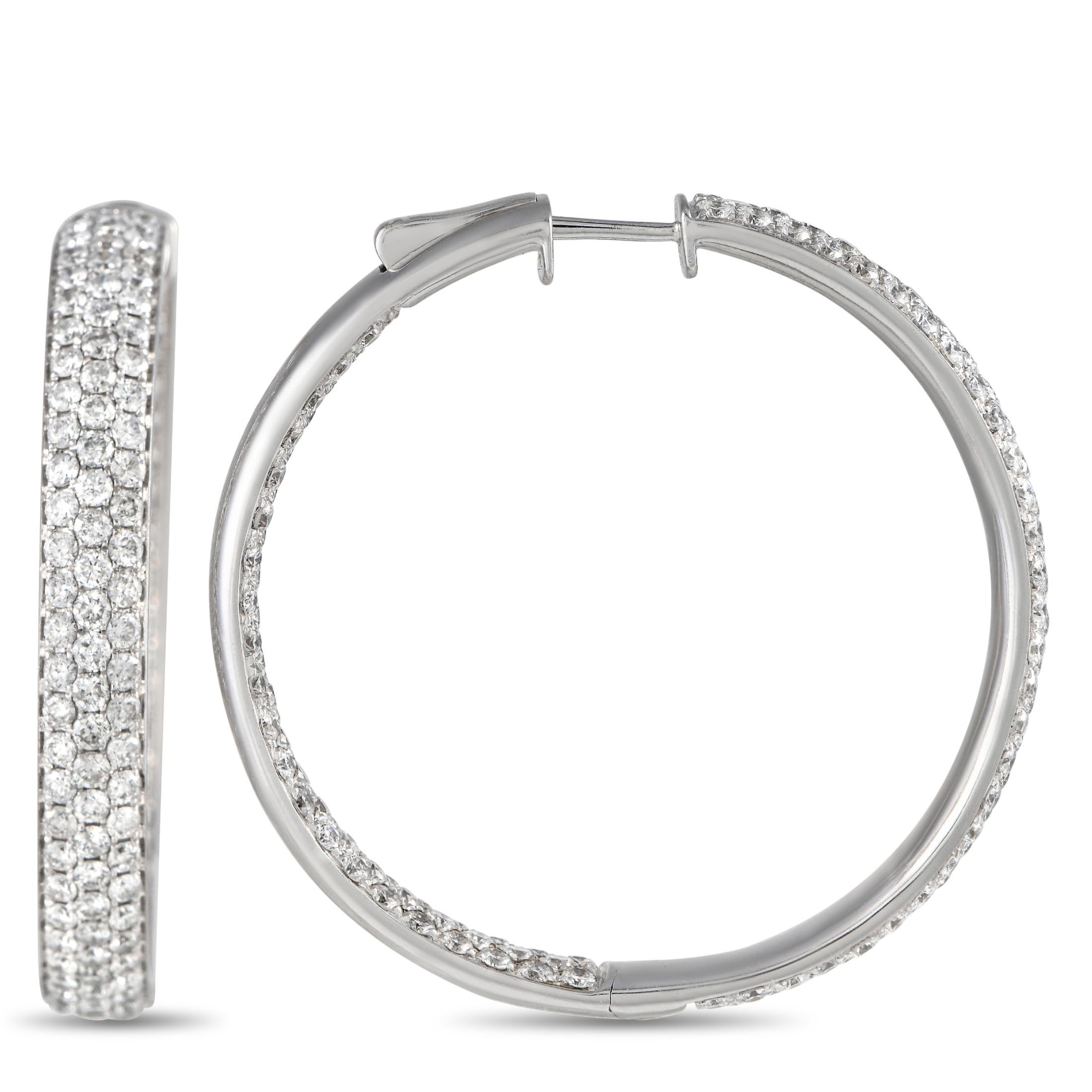Sparkling diamonds with a total weight of 6.10 carats make seemingly every inch of these exquisite hoop earrings come alive whenever they catch the light. Set in 14K White Gold, each one measures 1.5” round. 
 
This jewelry piece is offered in brand
