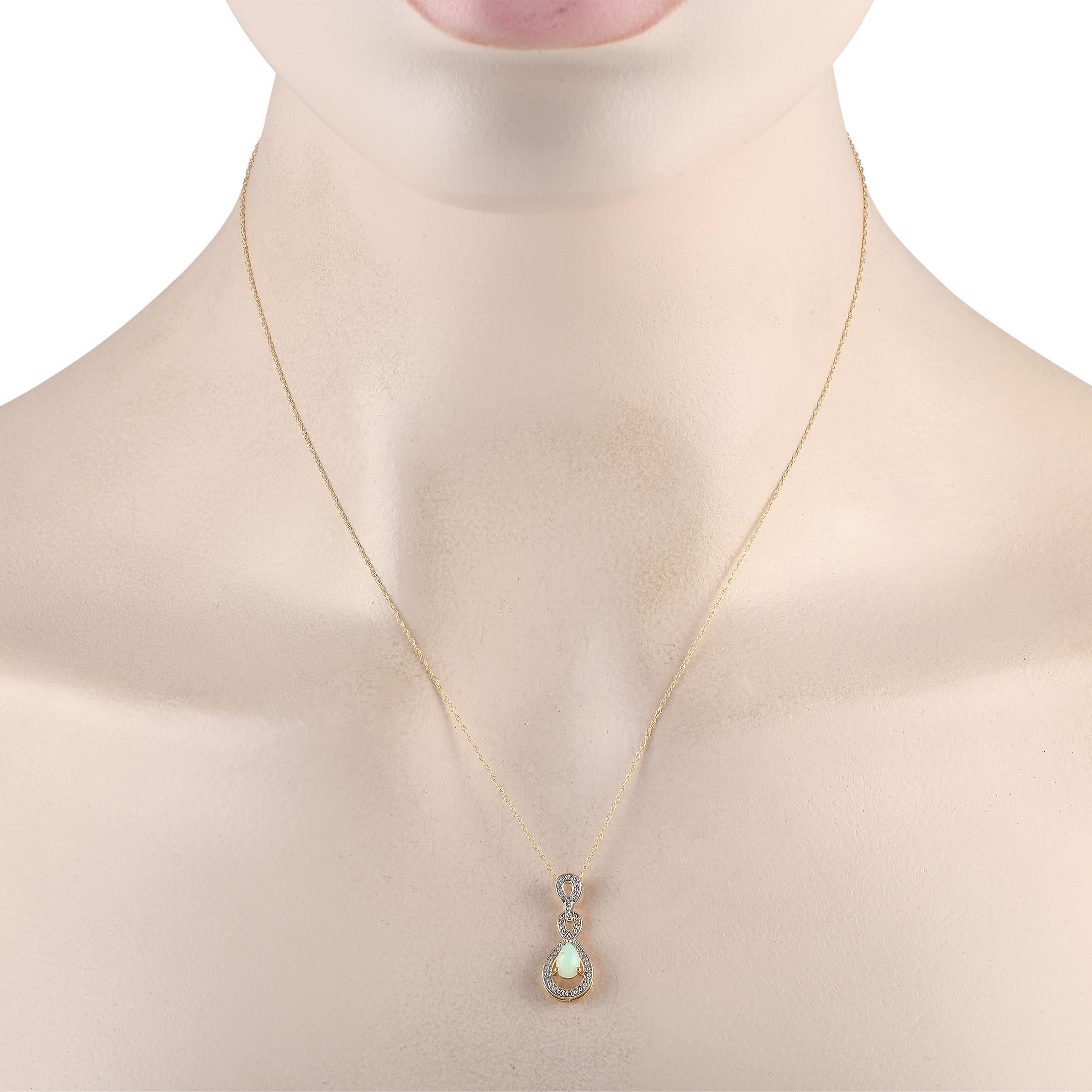 Une pierre centrale en Opale ardente ajoute de la couleur et de la dimension à ce collier élégant et discret. Sur ce pendentif complexe en or jaune 14K  qui mesure 0,85 de long sur 0,45 de large  des accents de diamants supplémentaires totalisant