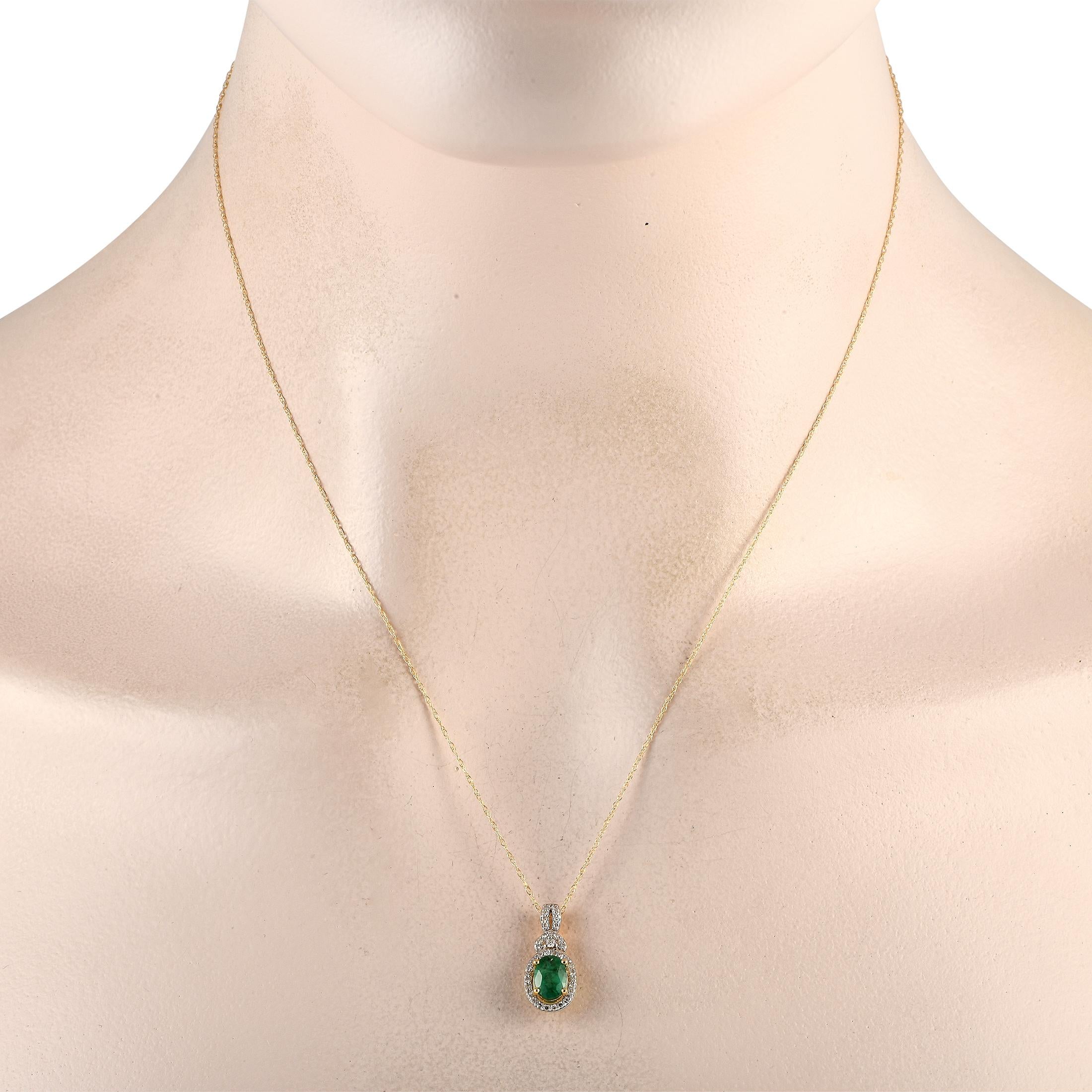 A classic piece that can be your new everyday piece. This 14K yellow gold necklace features a delicate cable chain measuring 18 inches long. It features a split-style bail traced with diamonds. The gorgeous green emerald stone haloed by an oval