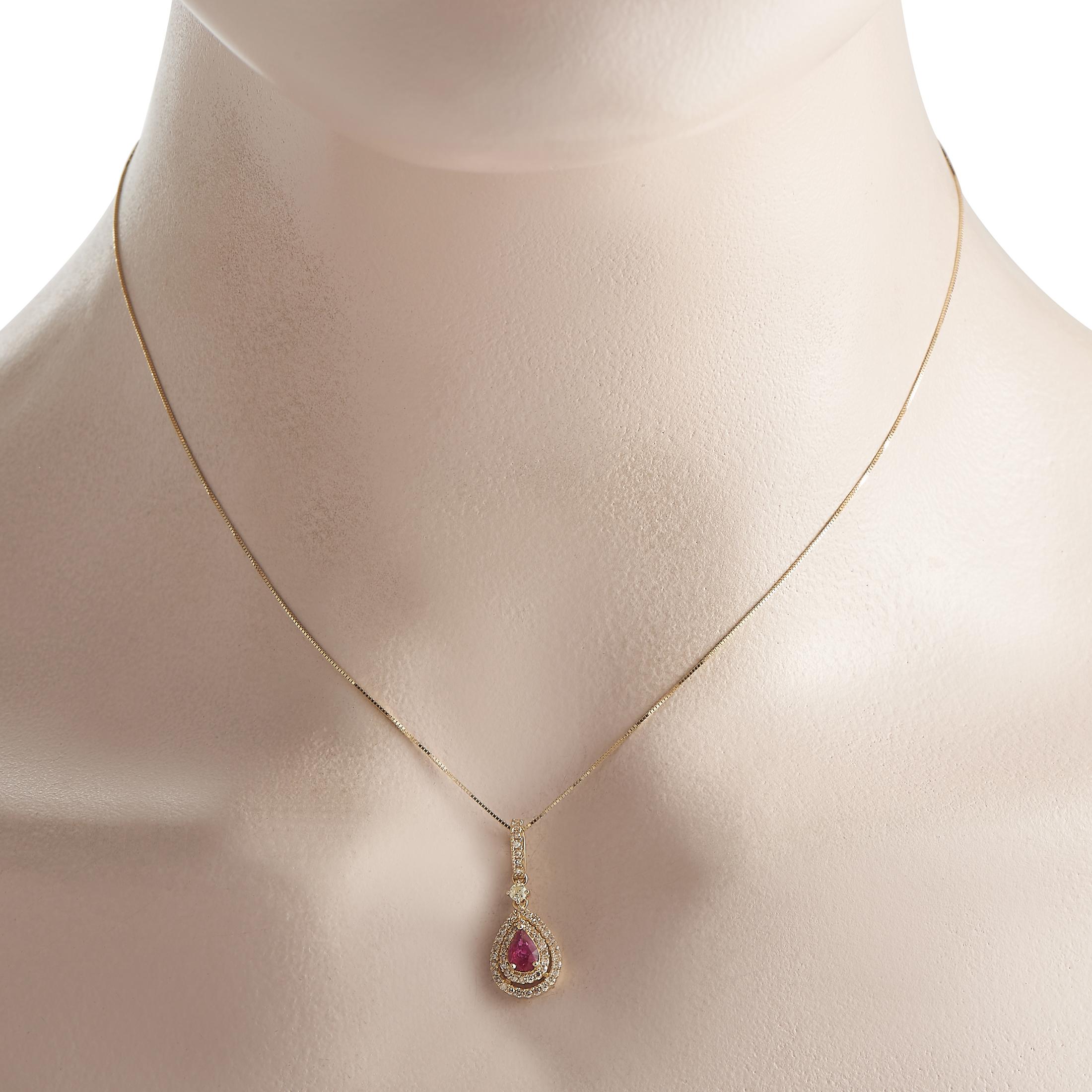 Der perfekte Begleiter für ein stilvolles Outfit zu jedem Anlass. Diese Gelbgold-Halskette mit einer 17-langen Box-Kette hält einen birnenförmigen Anhänger, der von einem schönen Rubin-Edelstein in der Mitte von zwei diamantbesetzten birnenförmigen